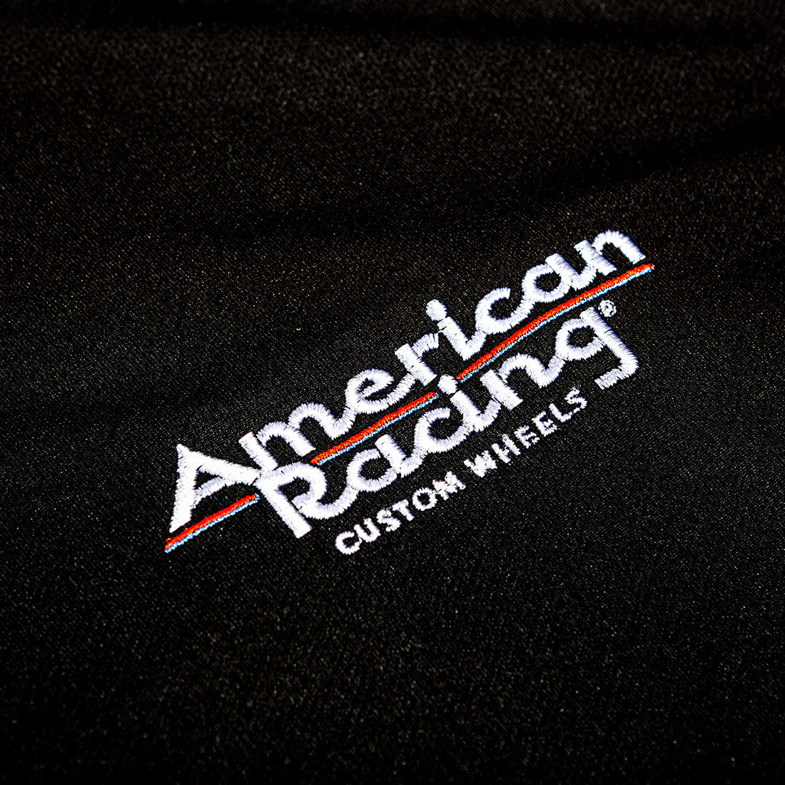 Black American Racing SPORT Polo with embroidered logo, short sleeves, and a classic collar.