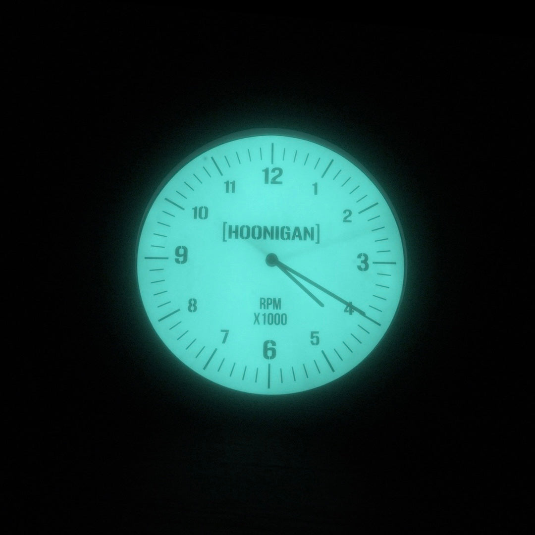Hoonigan 12-inch RPM glow clock with a luminous face displaying numbers and a needle, perfect for automotive enthusiasts.