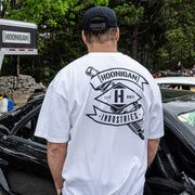 Man wearing a white Hoonigan LOW COMPRESSION short sleeve t-shirt, showcasing a bold graphic on the back.