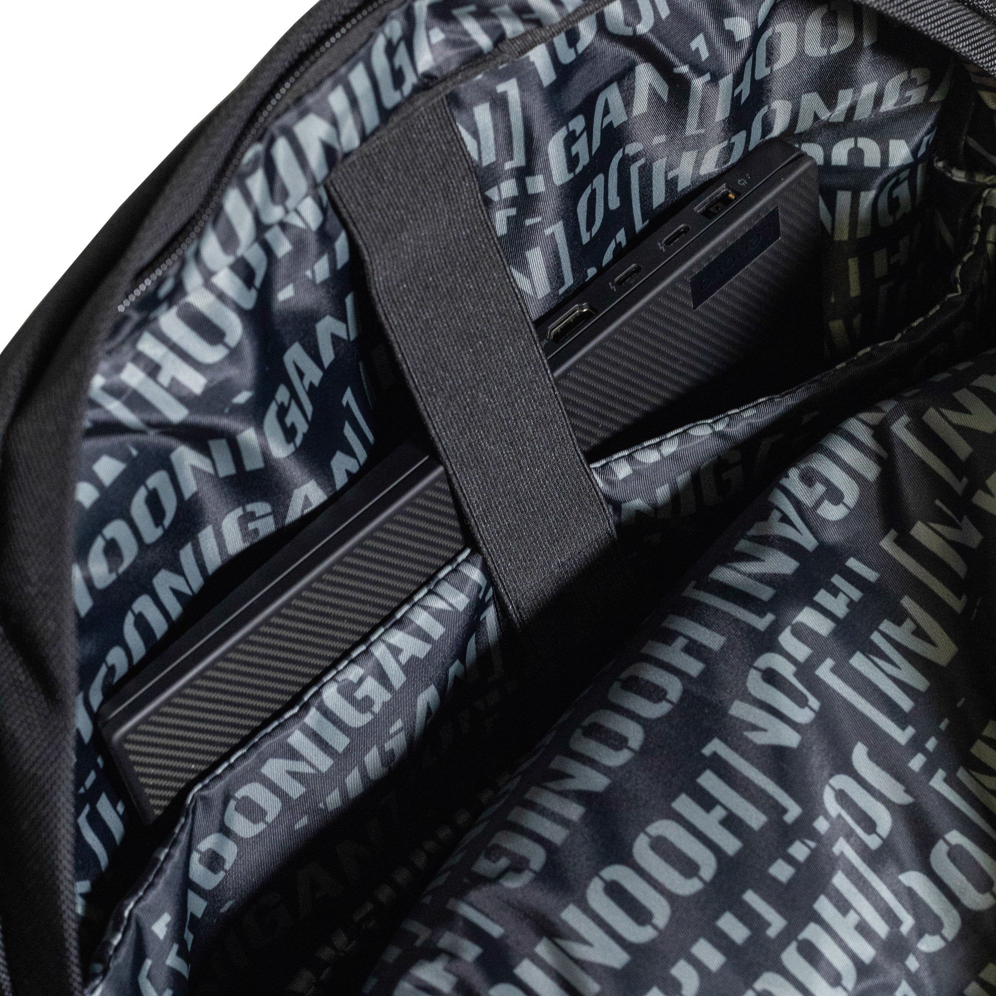 Hoonigan METAL BAR Backpack featuring a black fabric design with white logo, adjustable straps, and multiple compartments.