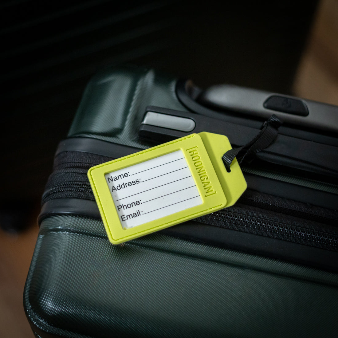 Hoonigan HI VIZ luggage tag in bright yellow with black logo and adjustable strap.