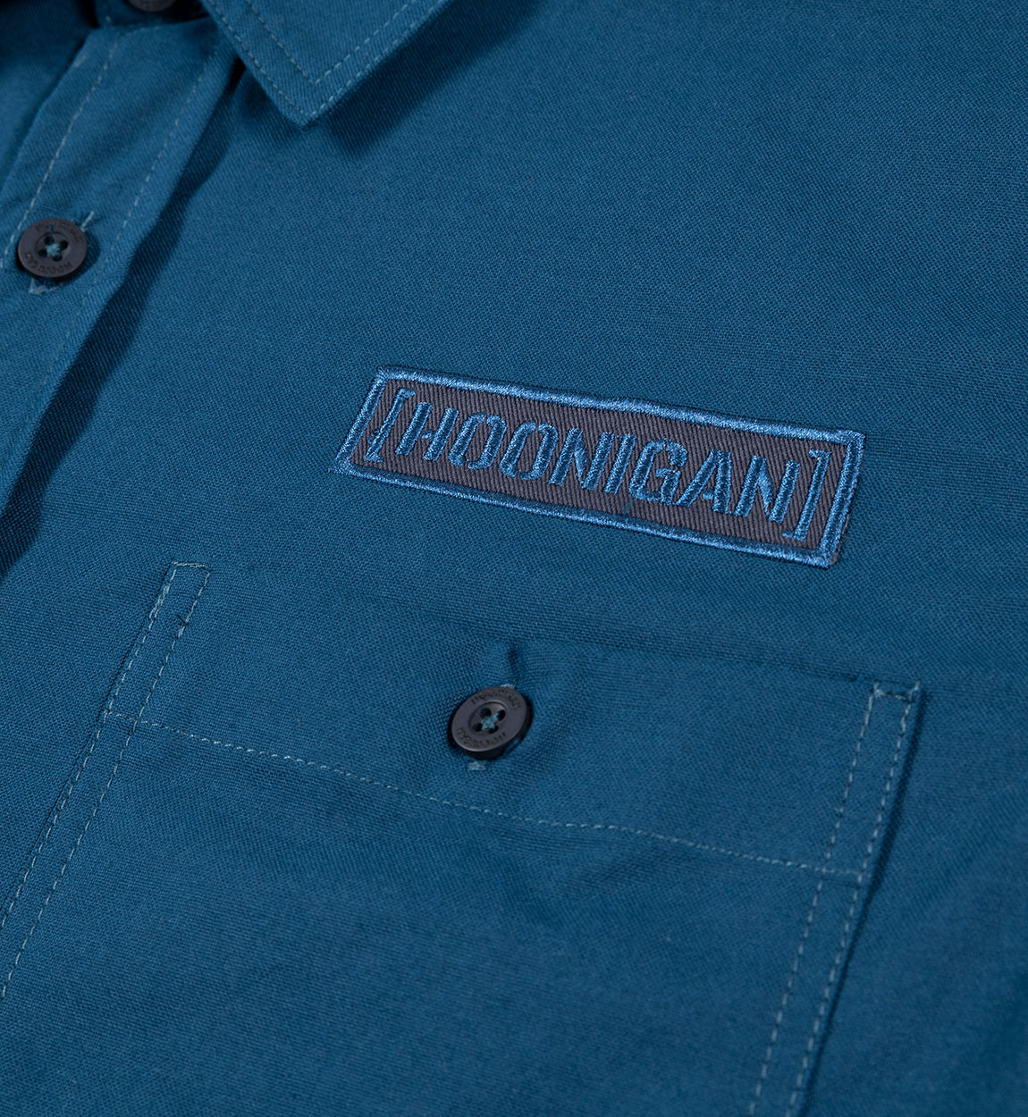 Hoonigan DONUT GARAGE navy short sleeve button-up shirt featuring a woven design and Hoonigan logo.