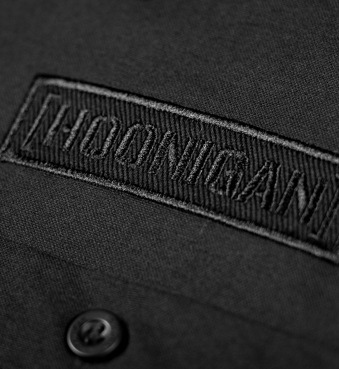 Hoonigan DONUT GARAGE black woven short sleeve button-up shirt featuring a logo on the left chest and a relaxed fit.