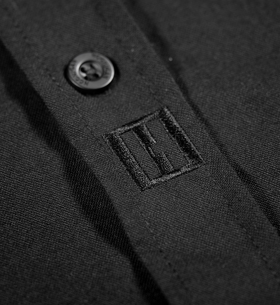 Hoonigan DONUT GARAGE black woven short sleeve button-up shirt displayed on a white background.