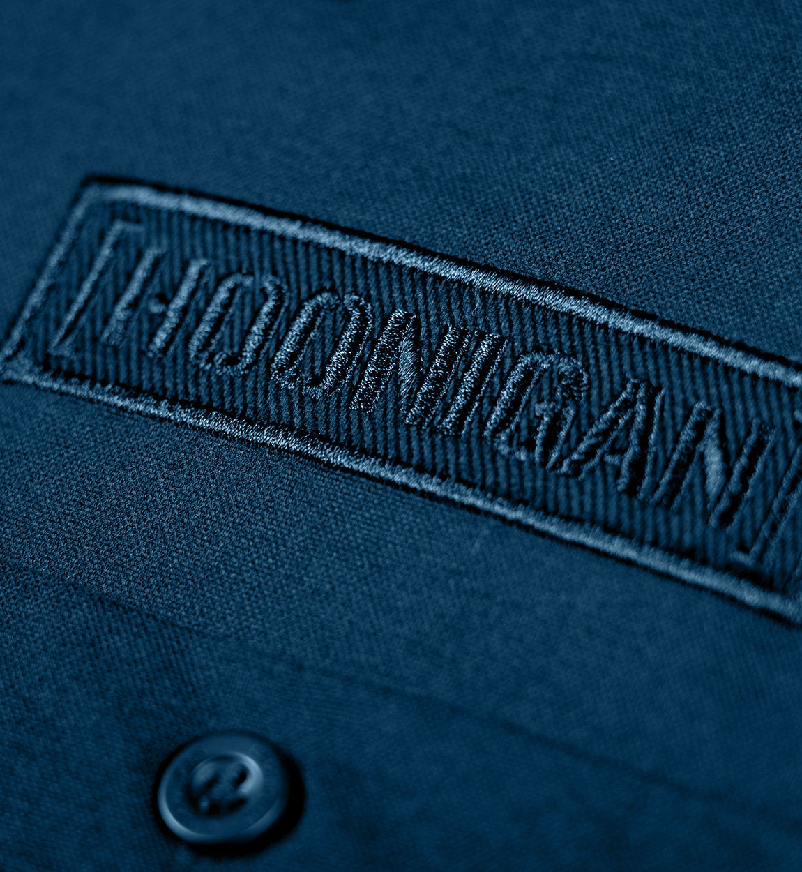 Hoonigan DONUT GARAGE Woven Long Sleeve Button-up Shirt in navy blue, featuring a front pocket and a classic button-up design.