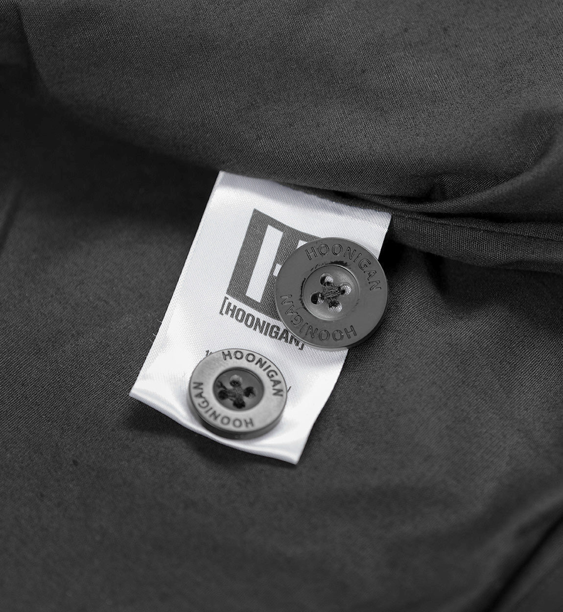 Hoonigan CHORE Jacket in black, featuring a front button closure, two chest pockets, and an embroidered logo on the left breast.