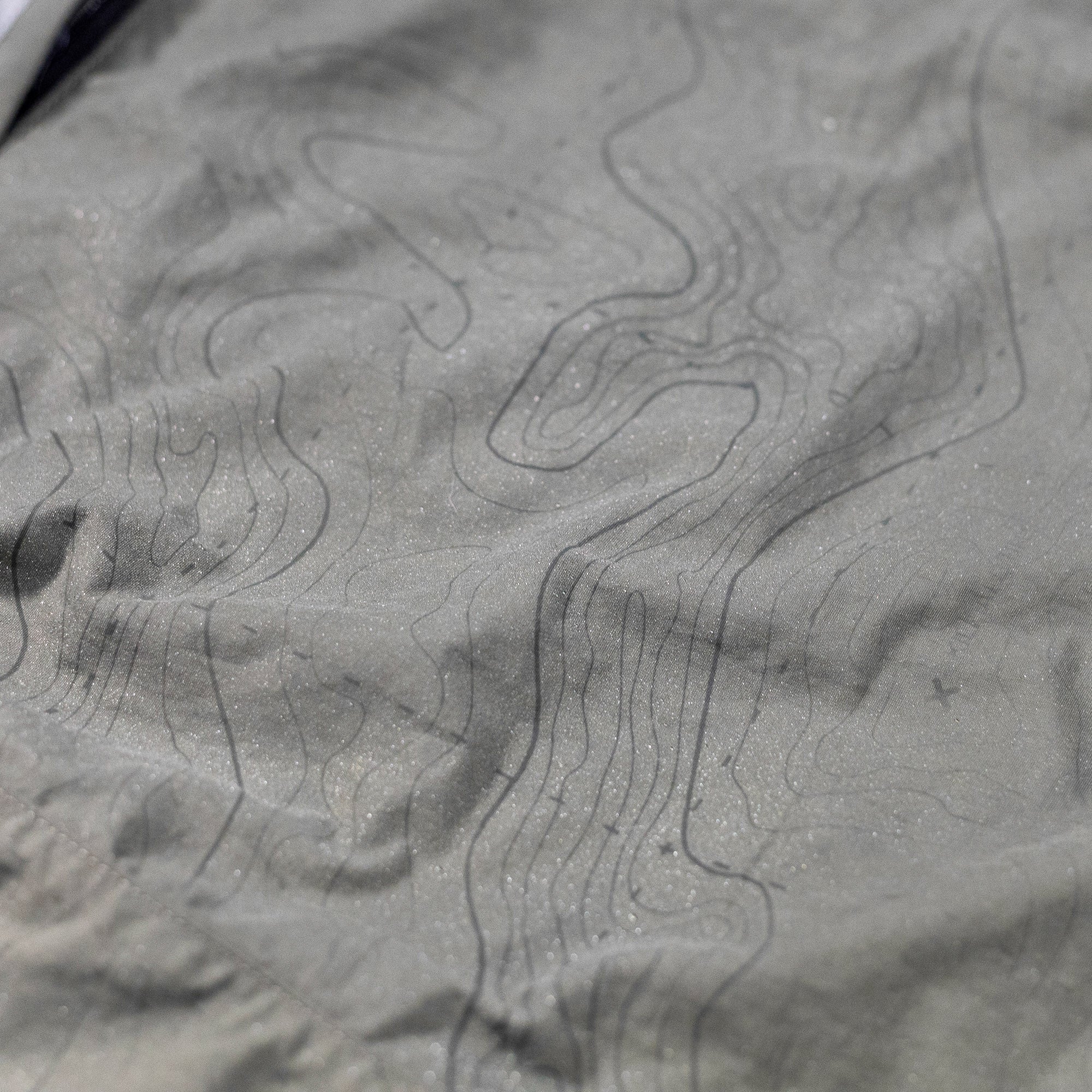 Close-up of Hoonigan H.A.V.O.C. rain-activated cargo shorts fabric with topographic line pattern and water-repellent texture.