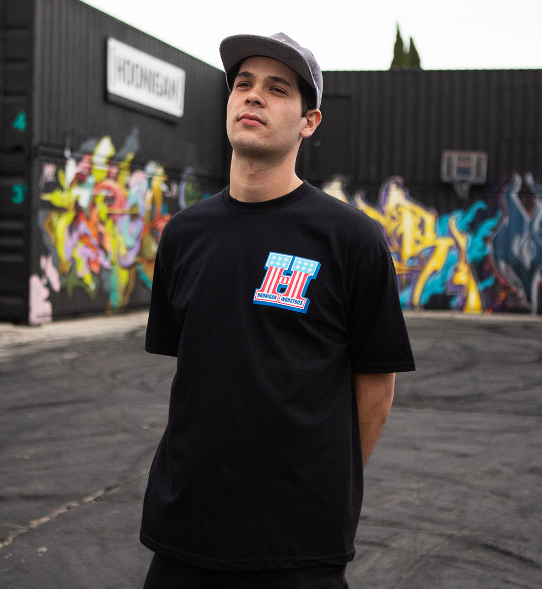 Hoonigan HARDTAIL short sleeve tee in black, worn by a model in an urban setting, showcasing a graphic logo on the front.