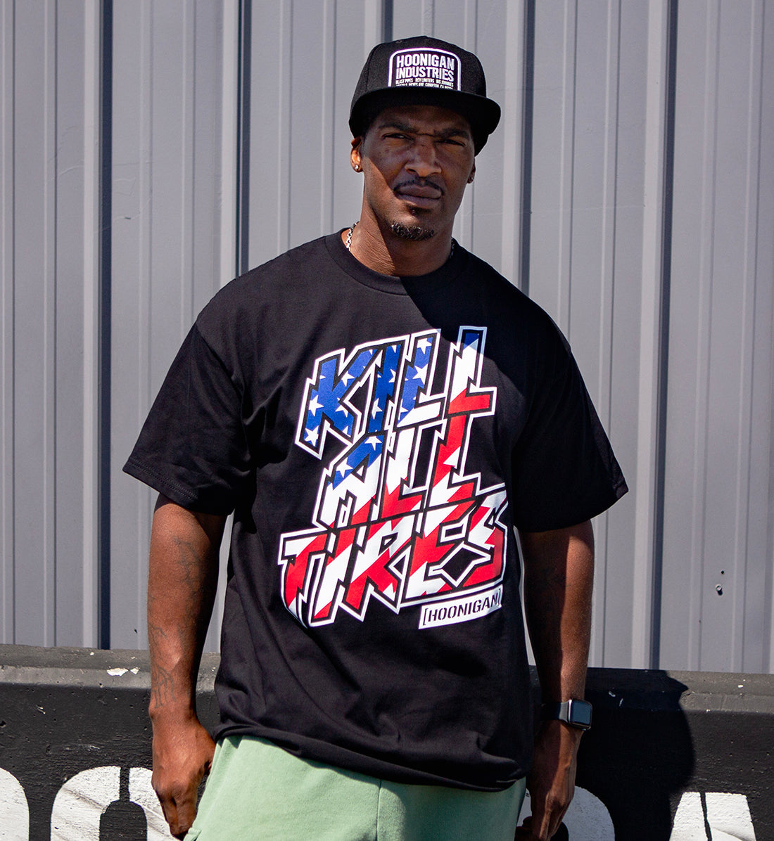 Black short sleeve tee featuring the Hoonigan "KILL ALL TIRES" graphic with stars and stripes design on the front.