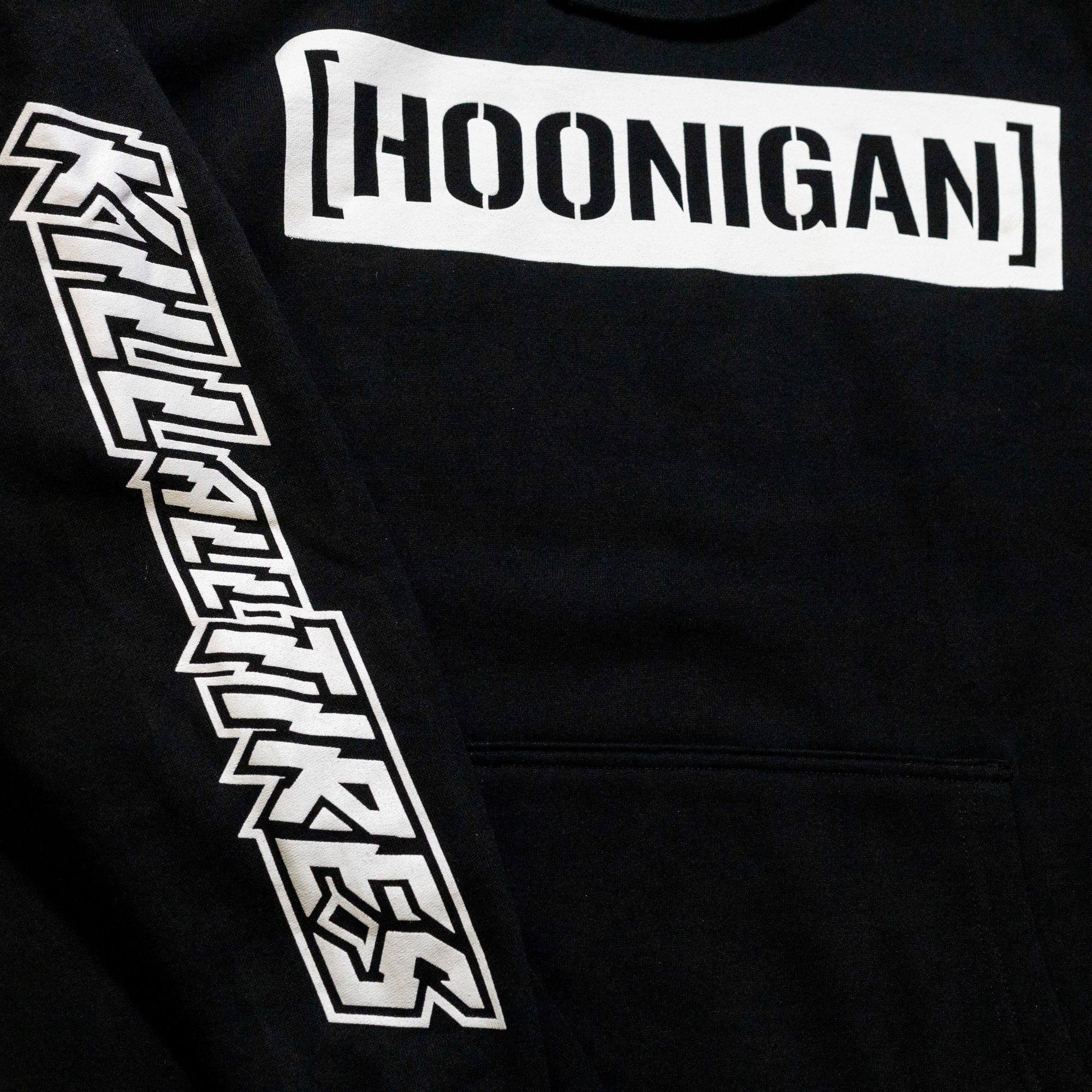 Black pullover hoodie featuring bold "[HOONIGAN]" logo and "KILL ALL TIRES" graphic on the sleeve. Ideal for motorsport enthusiasts.