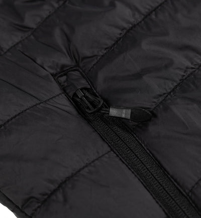 Close-up of a black GRILLE puffer vest showing a durable zipper and quilted, insulated fabric for warmth and style.