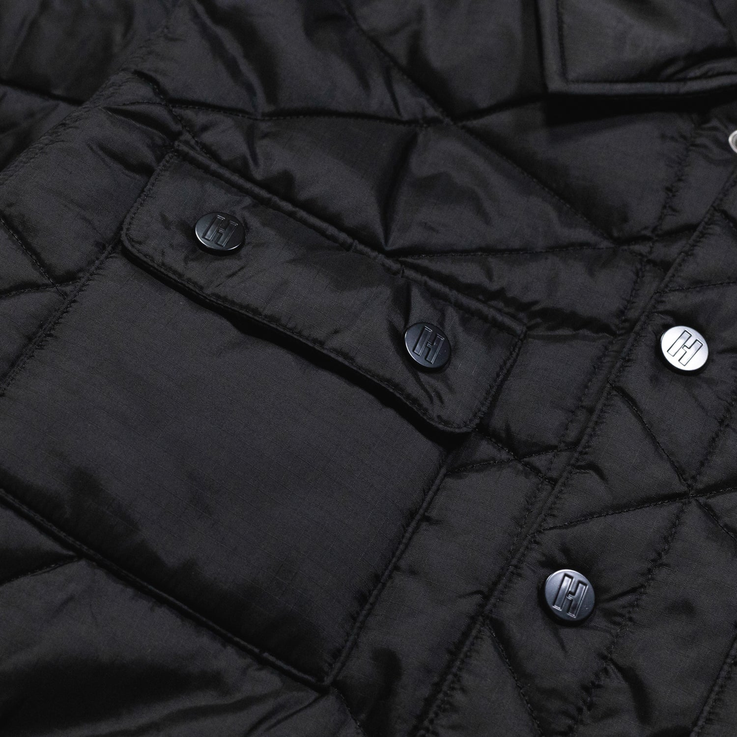 Hoonigan Motorsports VICTOR Quilted Jacket in black, featuring a stylish quilted design, zippered pockets, and the Hoonigan logo on the chest.