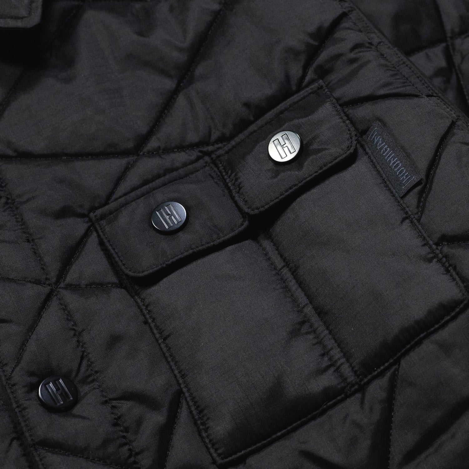 Hoonigan Motorsports VICTOR Quilted Jacket in black featuring a zip-up front, quilted design, and embroidered logo on the chest.
