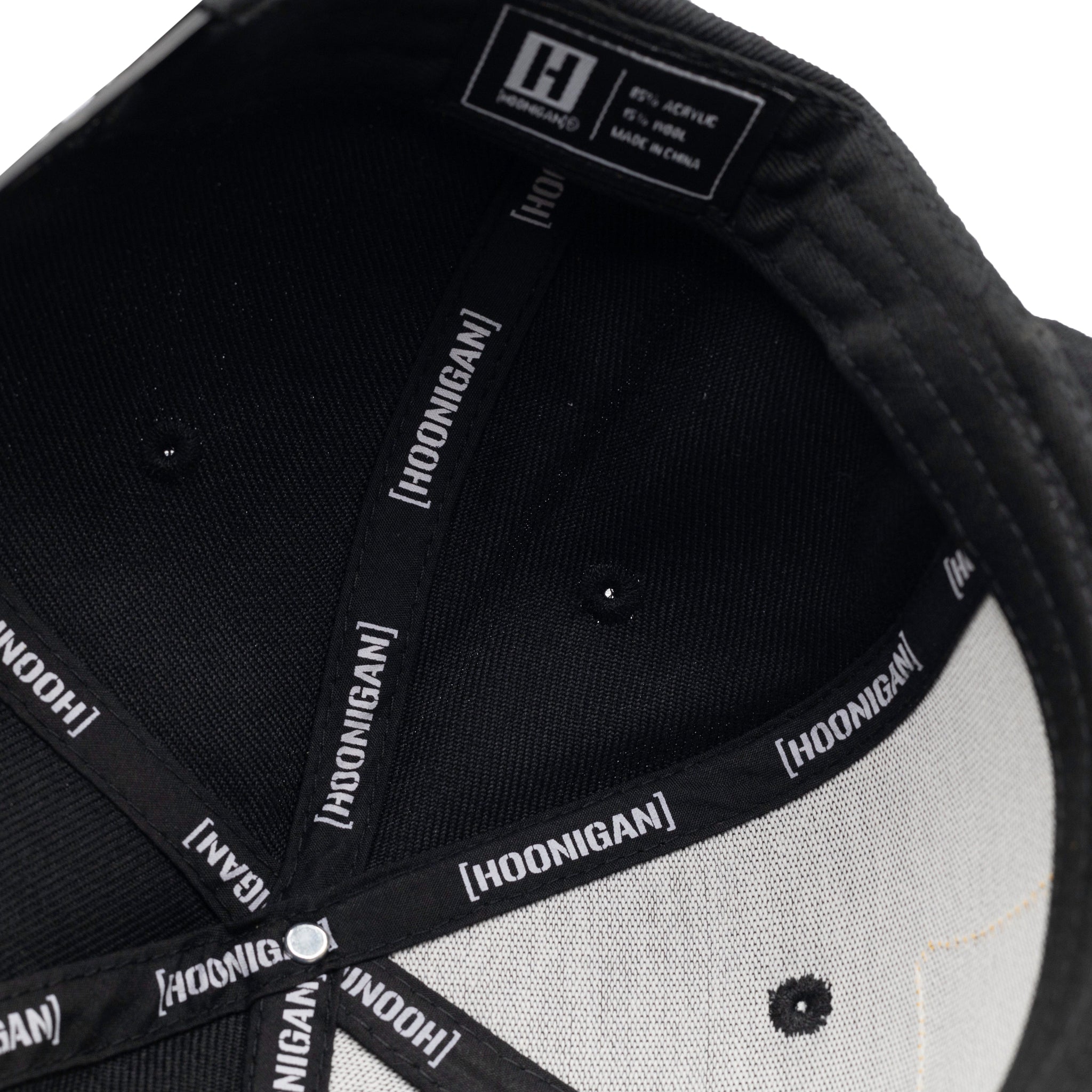 Hoonigan BELT SANDER Snapback Hat featuring a black base, bold graphics on the front, and an adjustable snapback design.