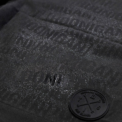 Close-up of Hoonigan Oil Slick Board Shorts featuring a textured logo and subtle sheen for a stylish, sporty look.