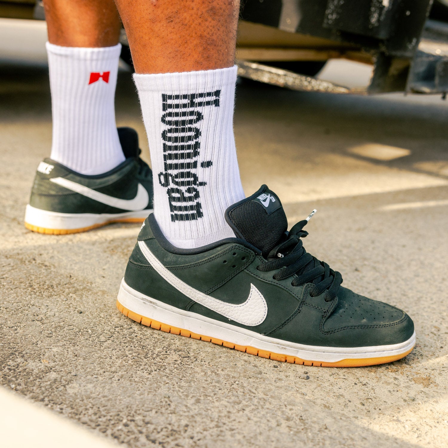 Black and white Hoonigan BURNOUT TEAM socks featuring bold branding and a checkered pattern.