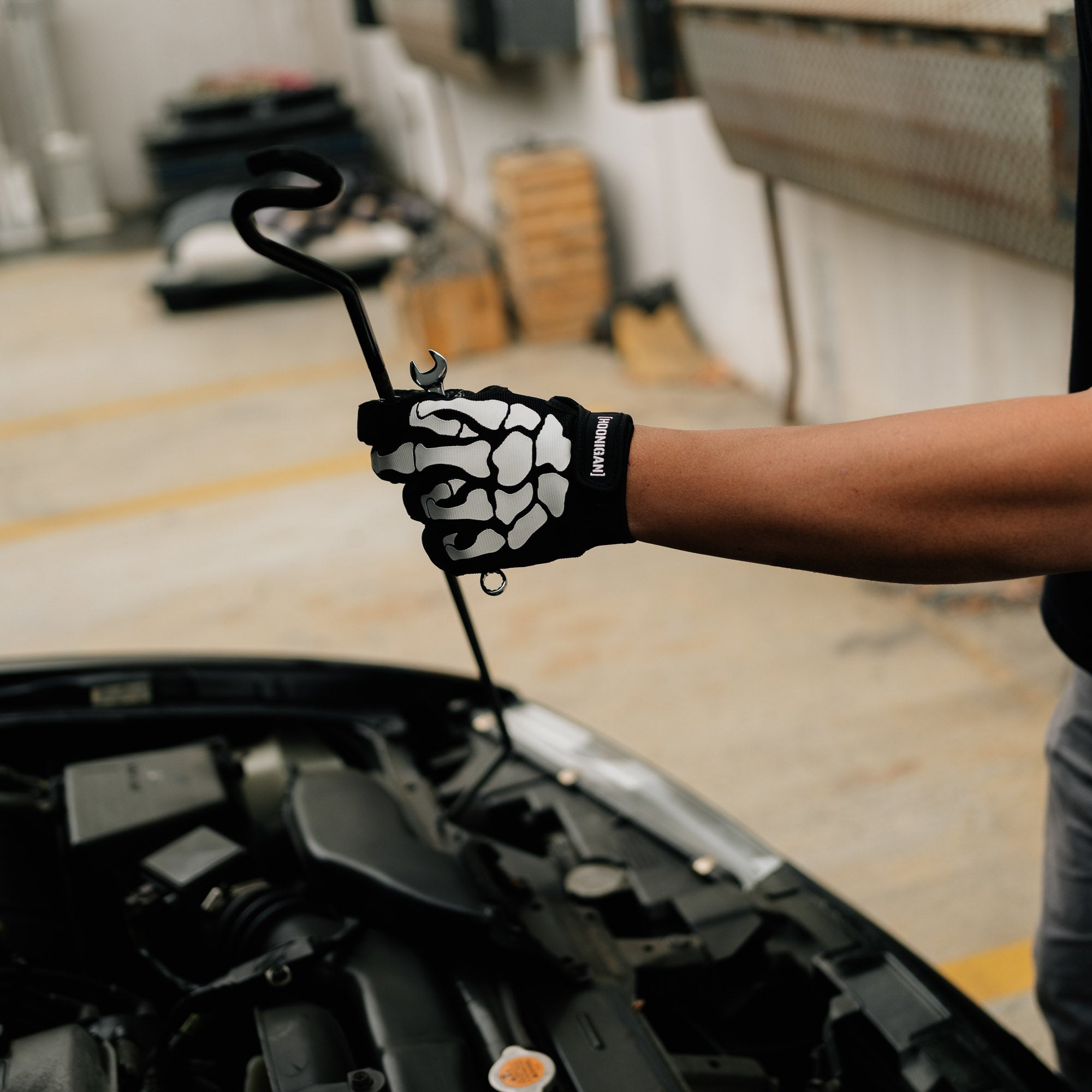 Hoonigan FIND OUT Gloves in black with white graphic design, featuring a textured grip and adjustable wrist strap.