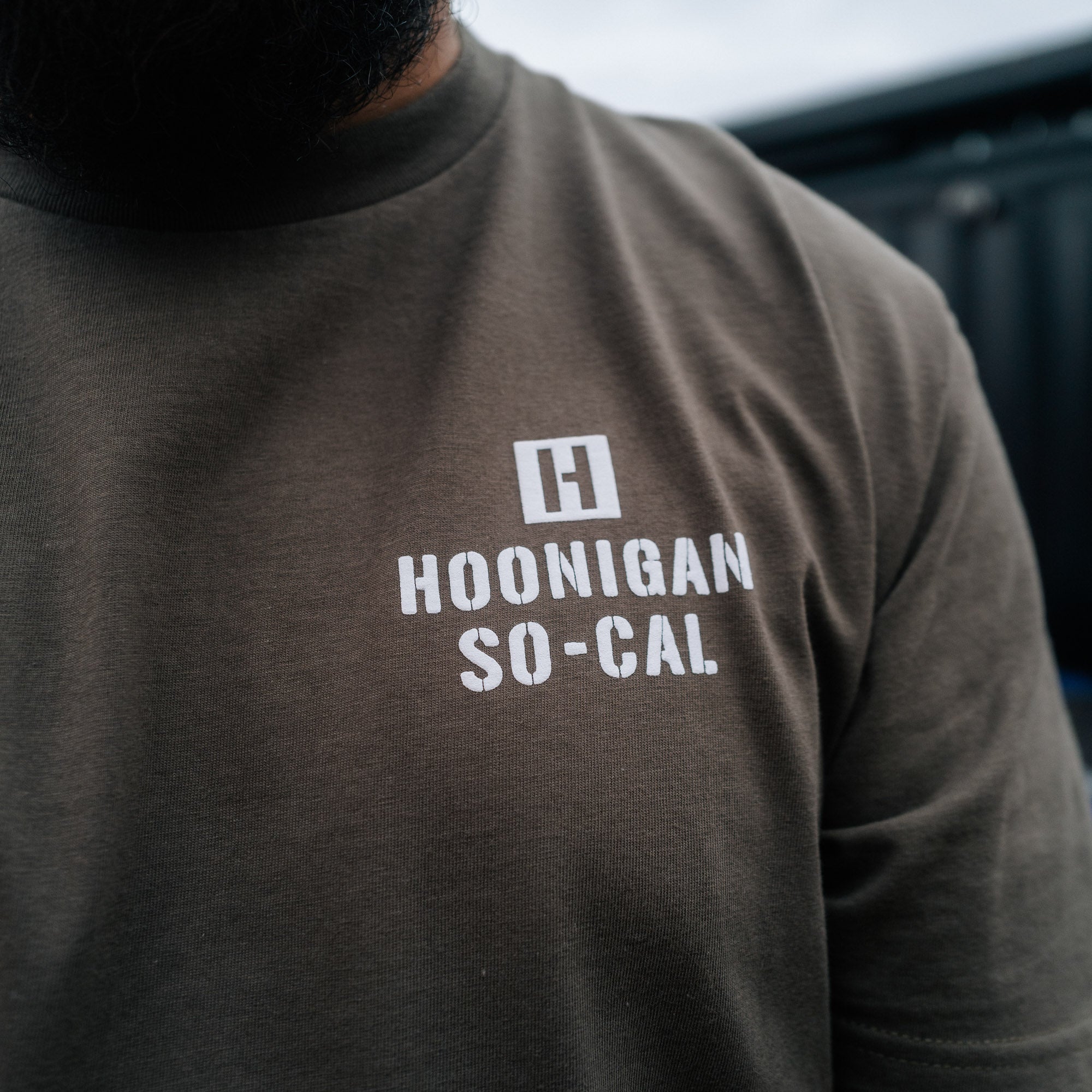 Black short sleeve Hoonigan STENCIL Tee featuring bold white "Hoonigan" logo graphic on the front.