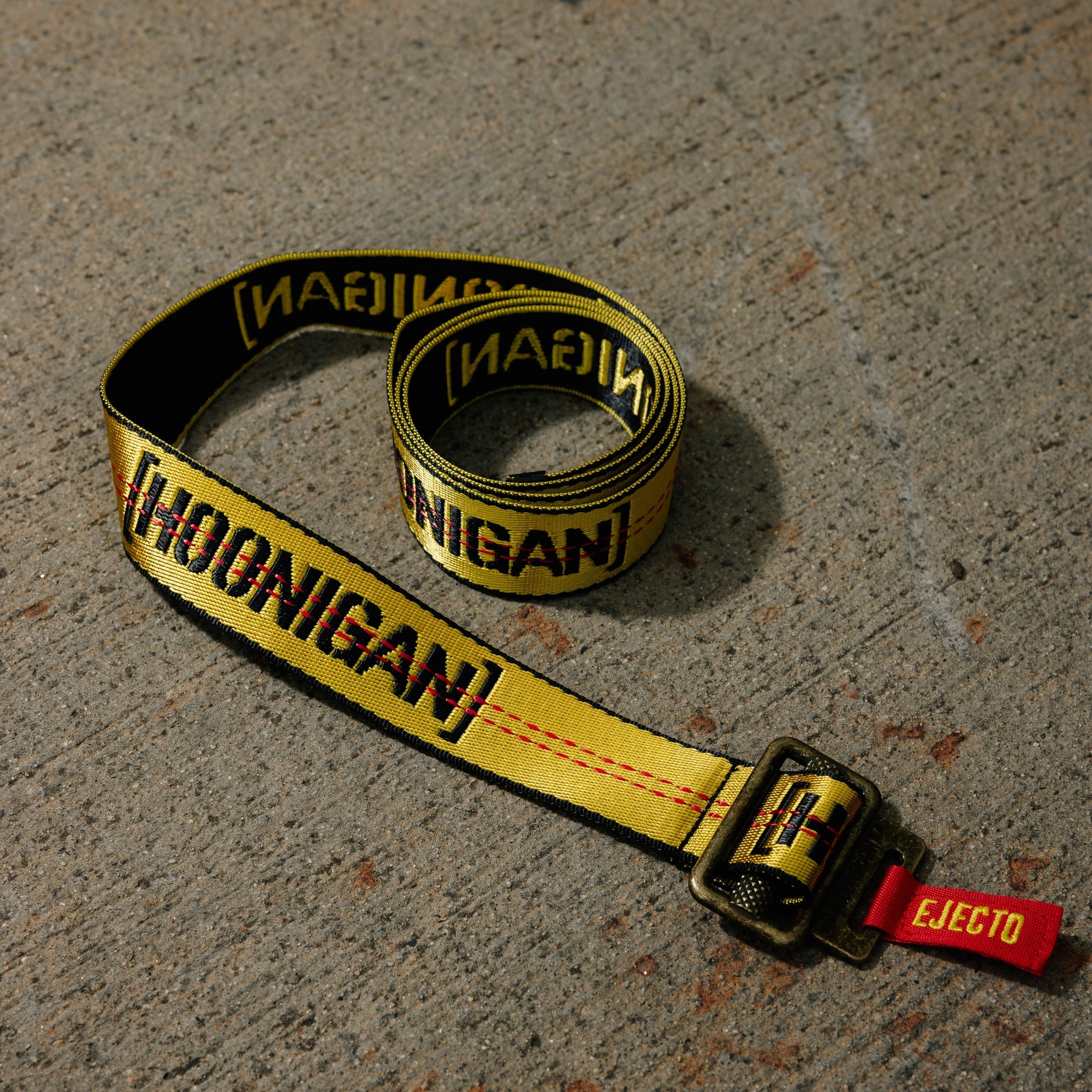 Hoonigan RATCHET Web Belt featuring a bold graphic design and adjustable ratchet buckle, displayed on a neutral background.