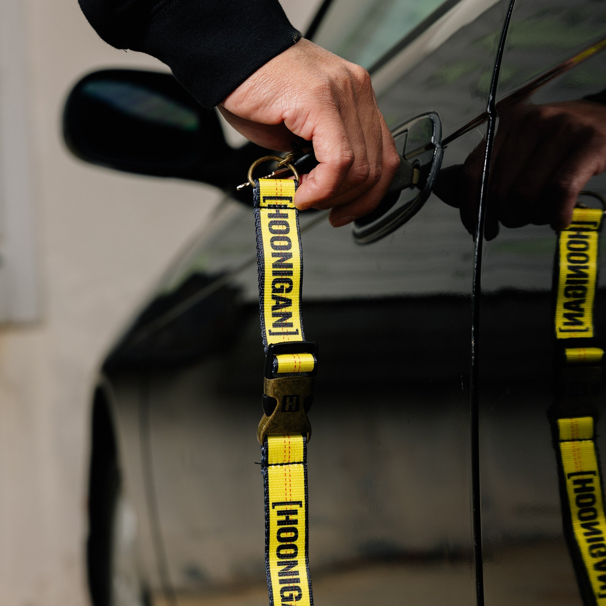 Hoonigan RATCHET STRAP lanyard featuring a durable design with a bold Hoonigan logo, perfect for securing items and easy carrying.