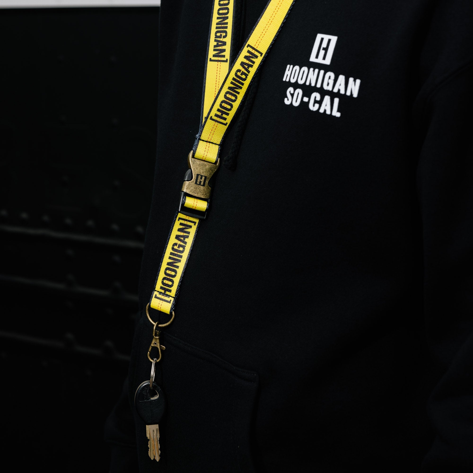 Hoonigan ratchet strap lanyard featuring a durable design and vibrant branding.