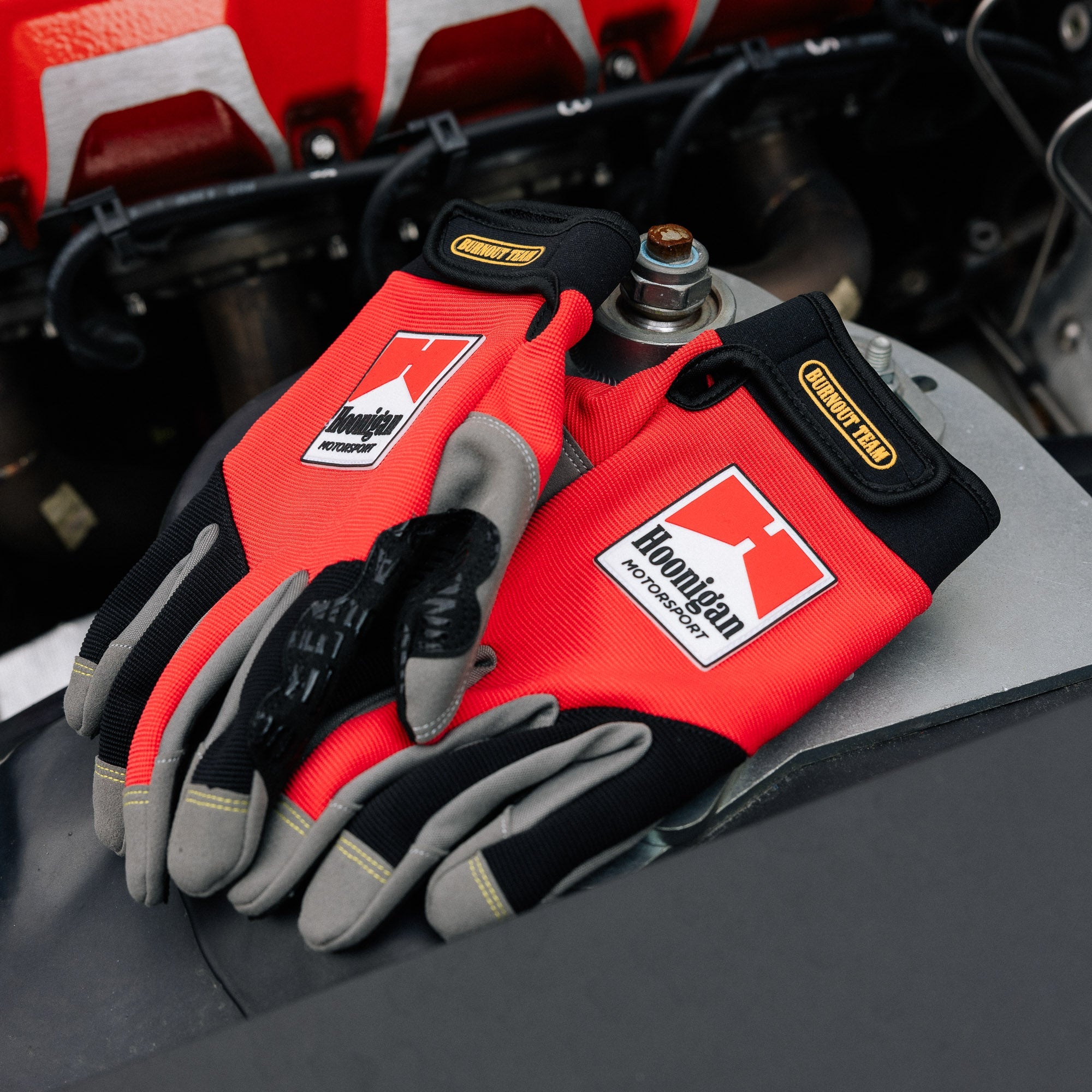 Hoonigan Surgeon General Gloves featuring a sleek black design with bold white graphics and logo.