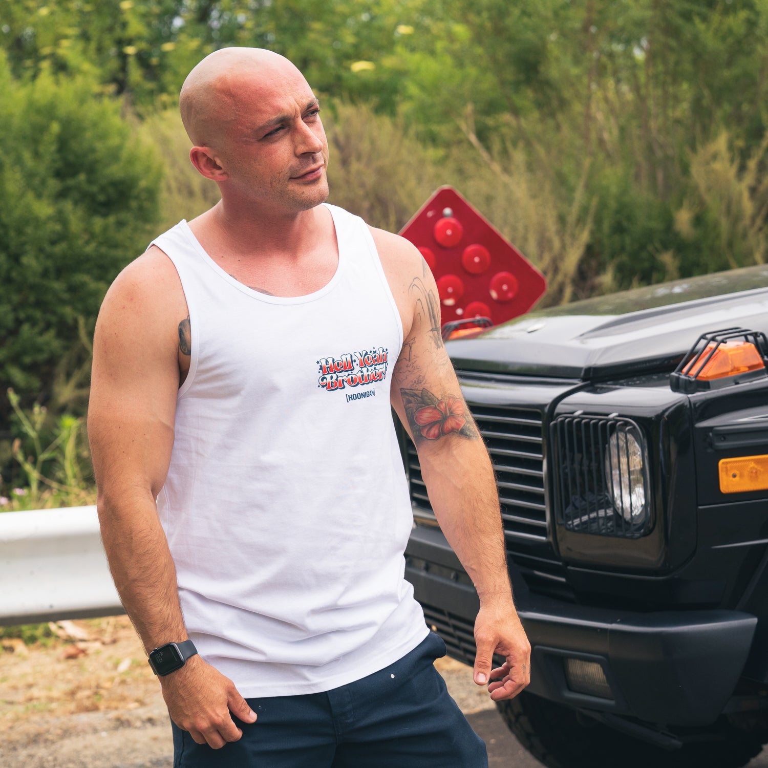 Hoonigan 'MERICA Tank Top featuring a patriotic design with bold lettering and a distressed American flag graphic on a black background.