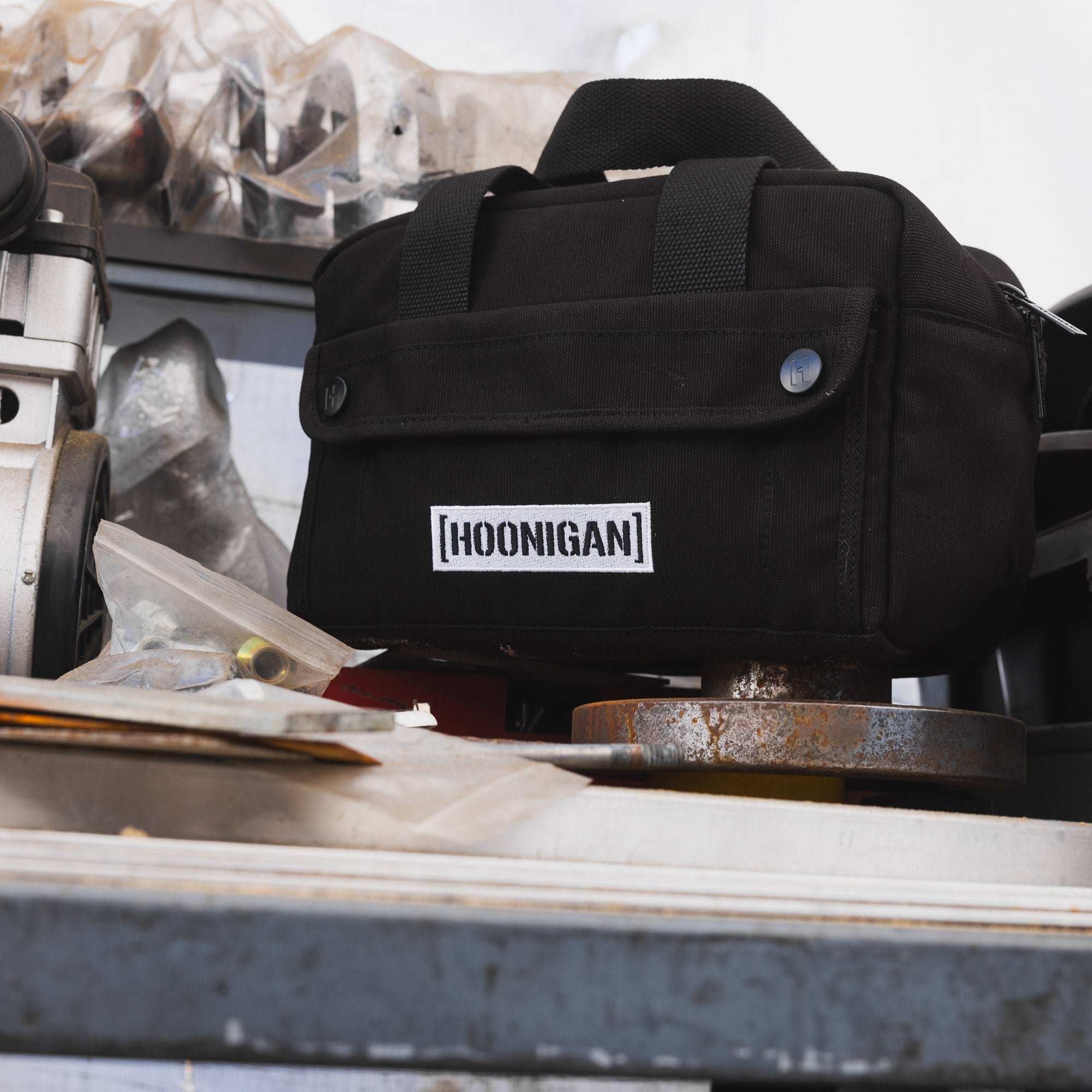Hoonigan CENSOR BAR Tool Bag in black with white logo, featuring multiple pockets and durable straps for versatile use.