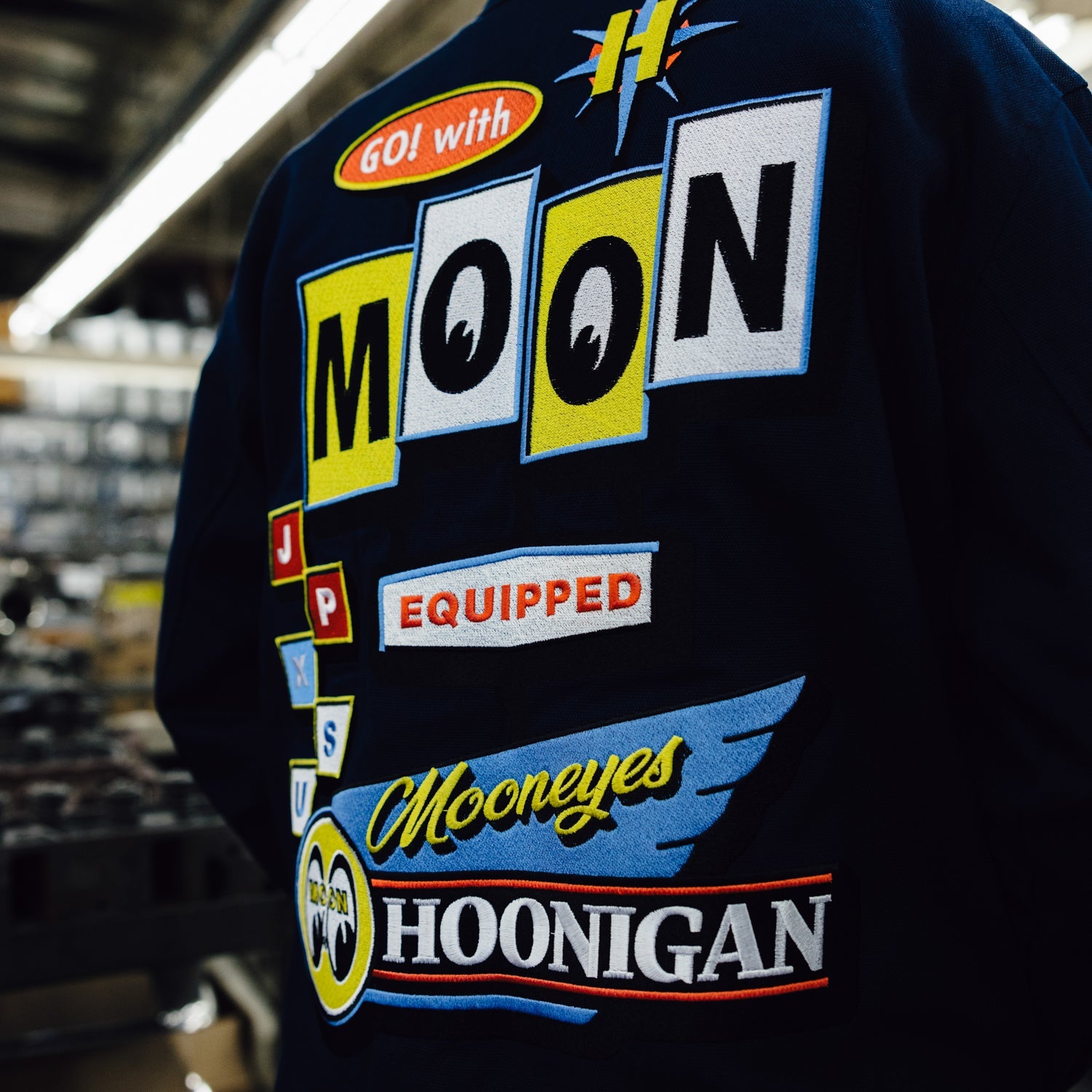 Hoonigan x Mooneyes MOON MOTEL Jacket featuring a bold graphic design, black fabric, and multiple front pockets.