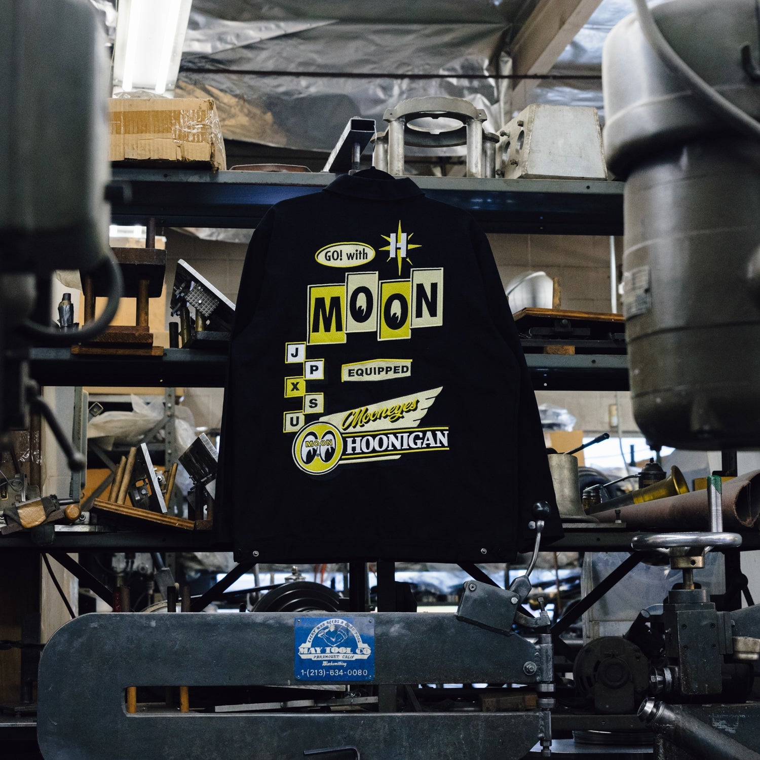 Hoonigan x Mooneyes MOON MOTEL black jacket featuring a retro graphic design on the back and front, with a zippered closure and ribbed cuffs.