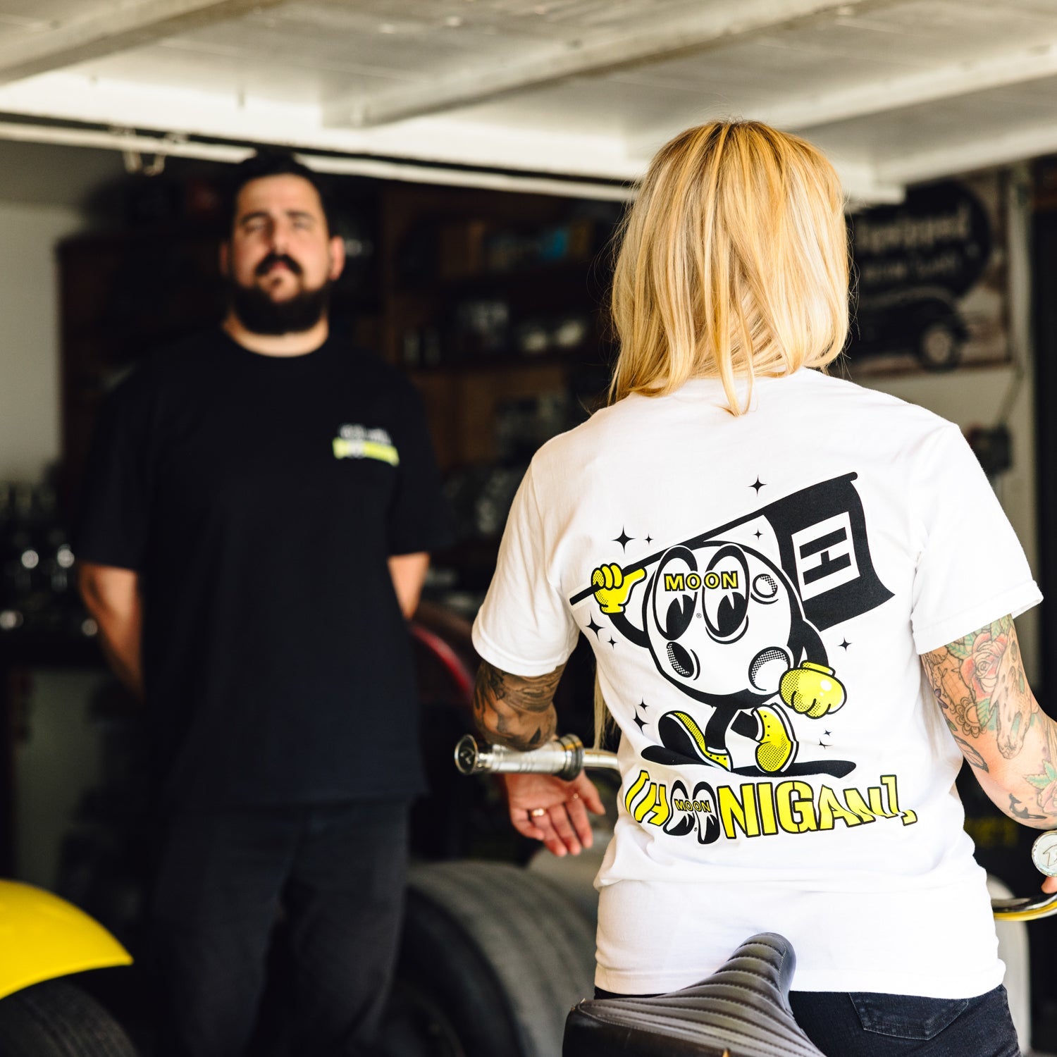 Hoonigan x Mooneyes MASCOT Short Sleeve Tee featuring a graphic logo design on a black fabric background.