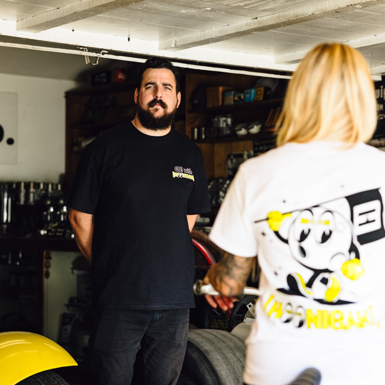 Hoonigan x Mooneyes MASCOT Short Sleeve Tee featuring a graphic design of a cartoon mascot on a black background.