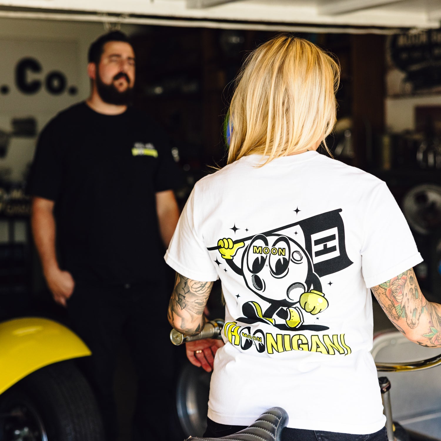 Hoonigan x Mooneyes short sleeve tee featuring a bold graphic design and vibrant colors on a black background.