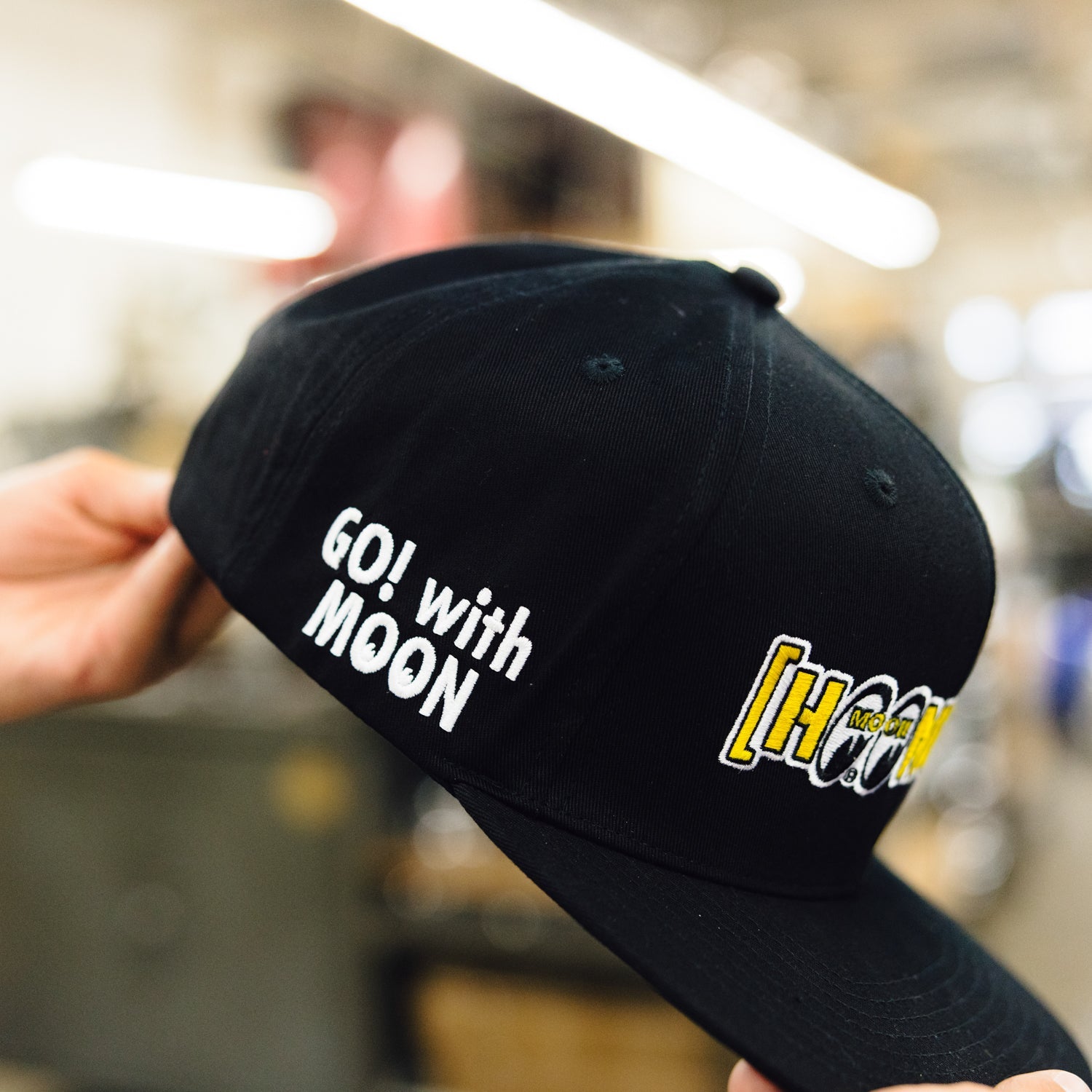 Hoonigan x Mooneyes MOON BAR Snapback Hat featuring a black design with a white embroidered logo on the front.