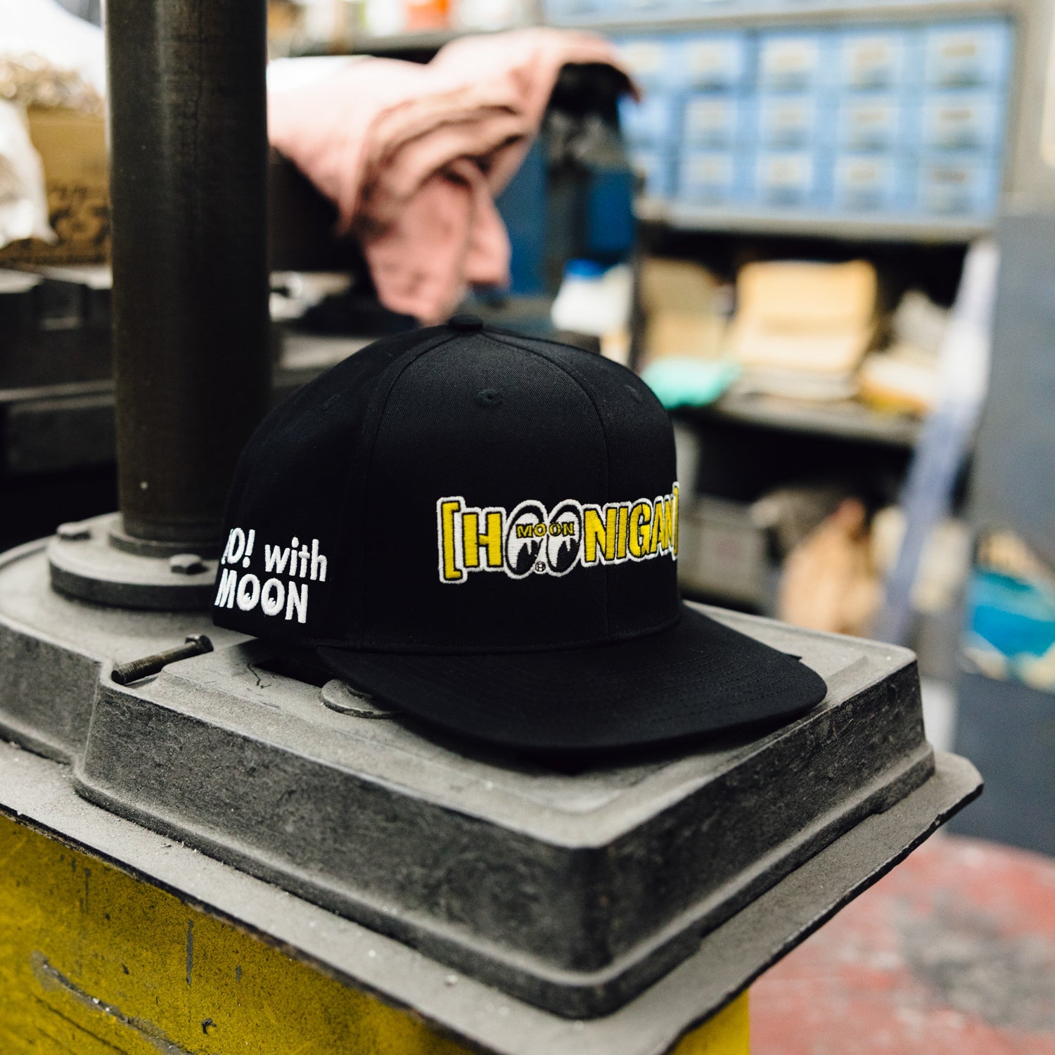 Hoonigan x Mooneyes MOON BAR Snapback Hat featuring a black crown, yellow embroidered logo, and a classic flat brim.