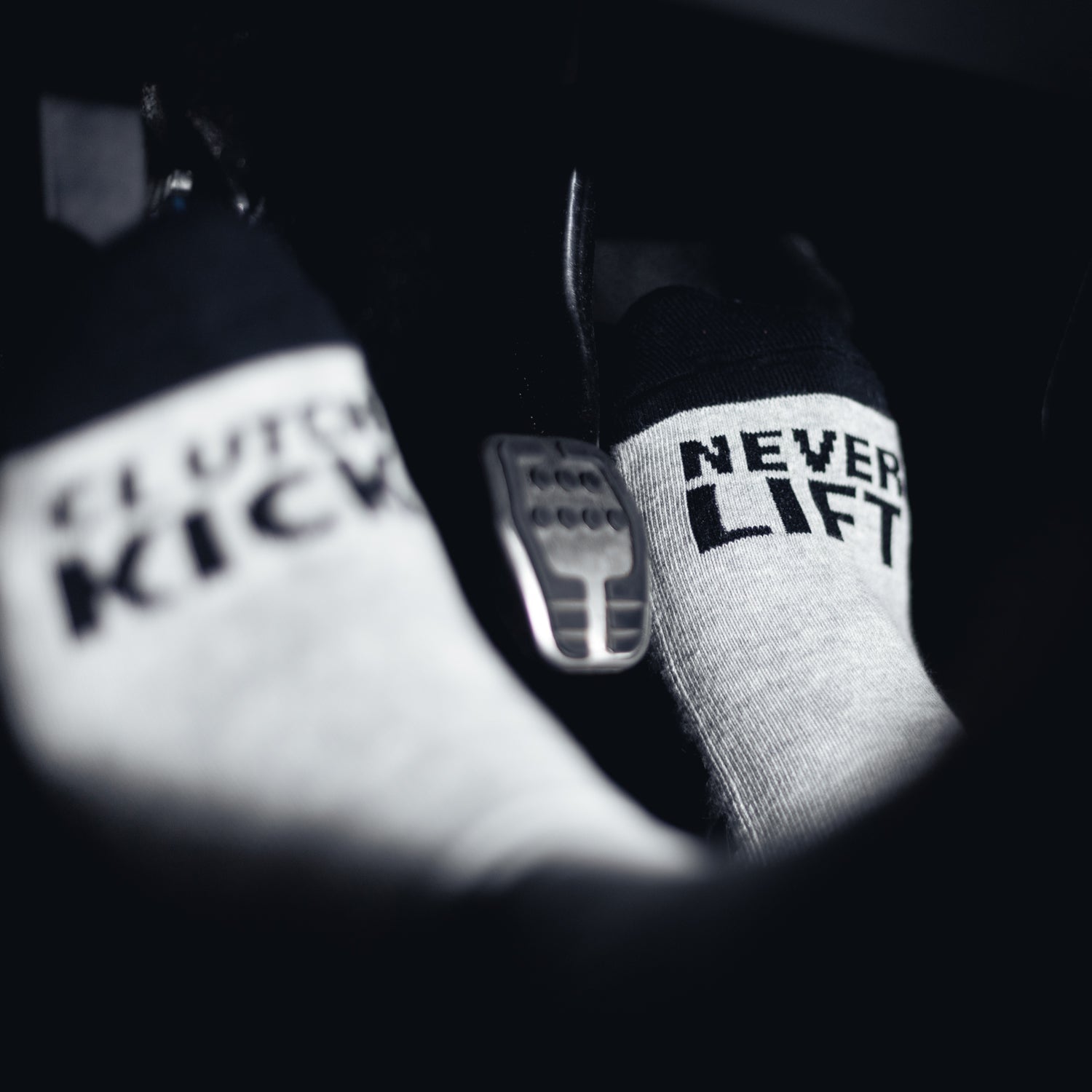 Hoonigan NEVER LIFT socks featuring a bold black design with white text, ideal for motorsport enthusiasts.