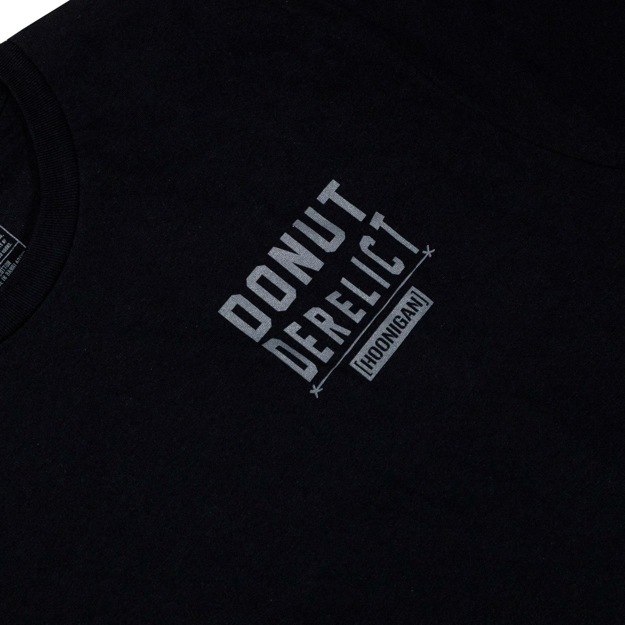 Black short sleeve t-shirt featuring the Hoonigan Donut Derelict logo in bold white lettering. Perfect for car culture enthusiasts.