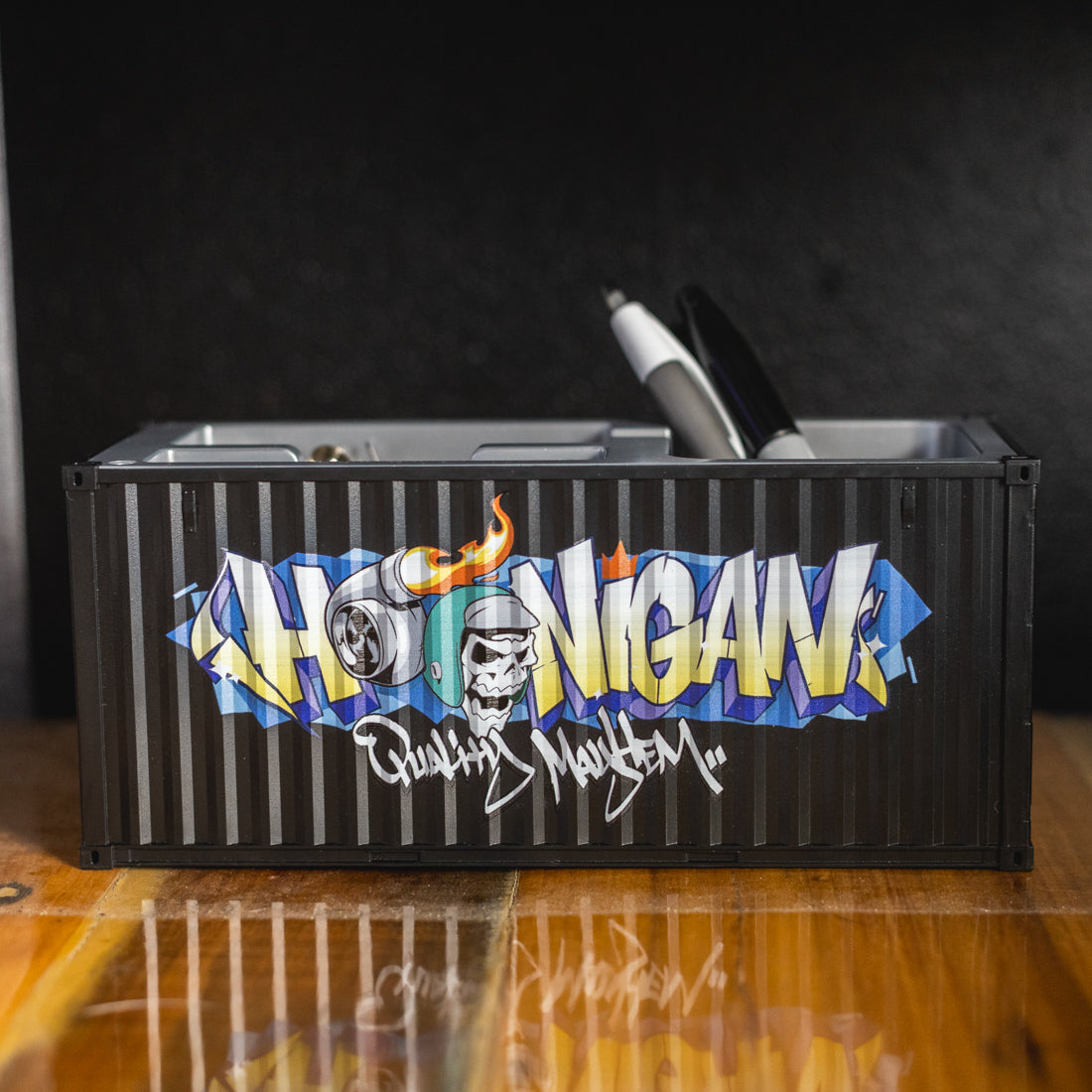 Alt text: Hoonigan X Spen1 branded mini shipping container in teal color with detailed graphics and a matte finish.