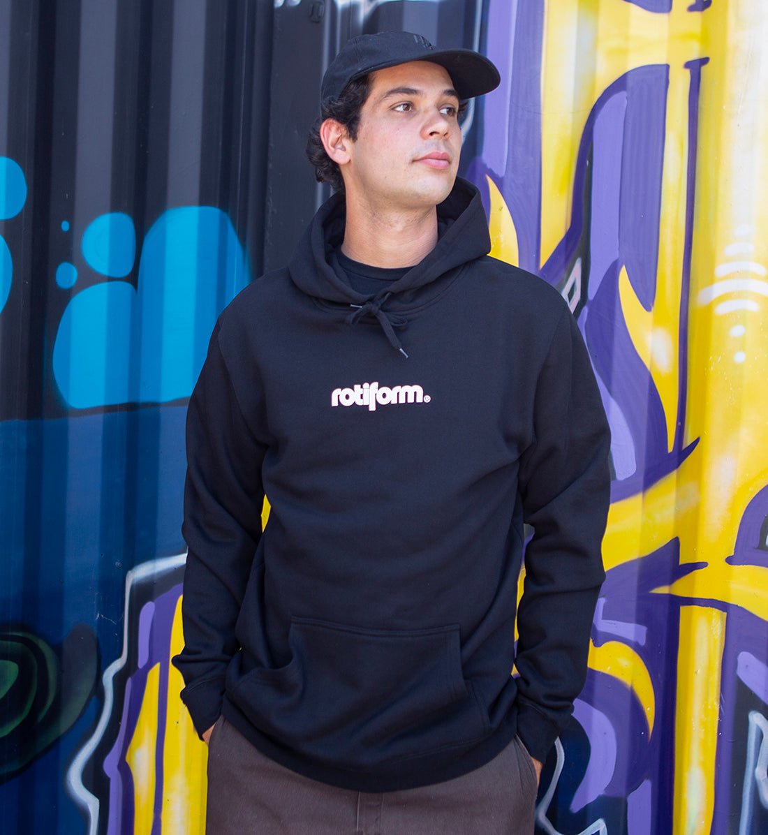 Black and white Rotiform STAPLE hoodie featuring a front logo design, modeled casually in a lifestyle setting.