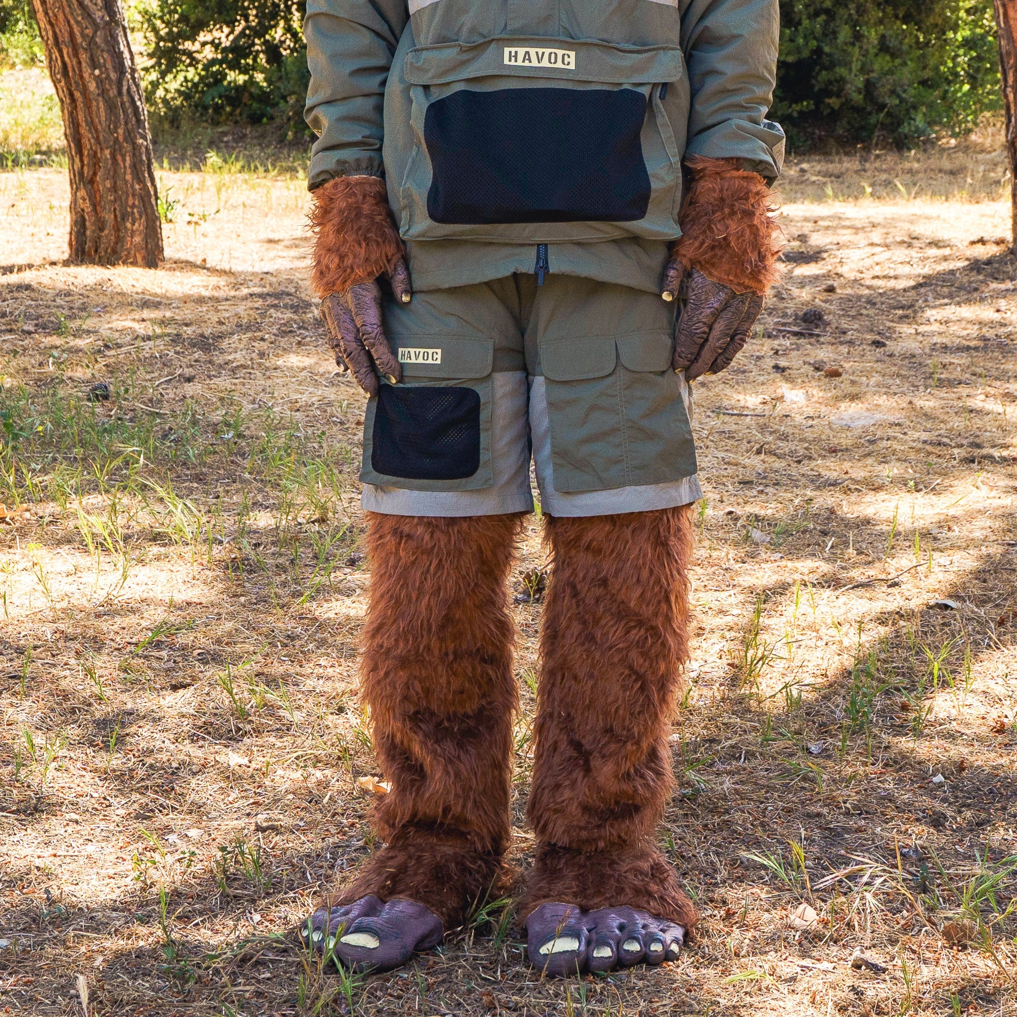Rain-activated cargo shorts with multiple pockets, worn by a person in a furry costume, outdoors in a wooded area.