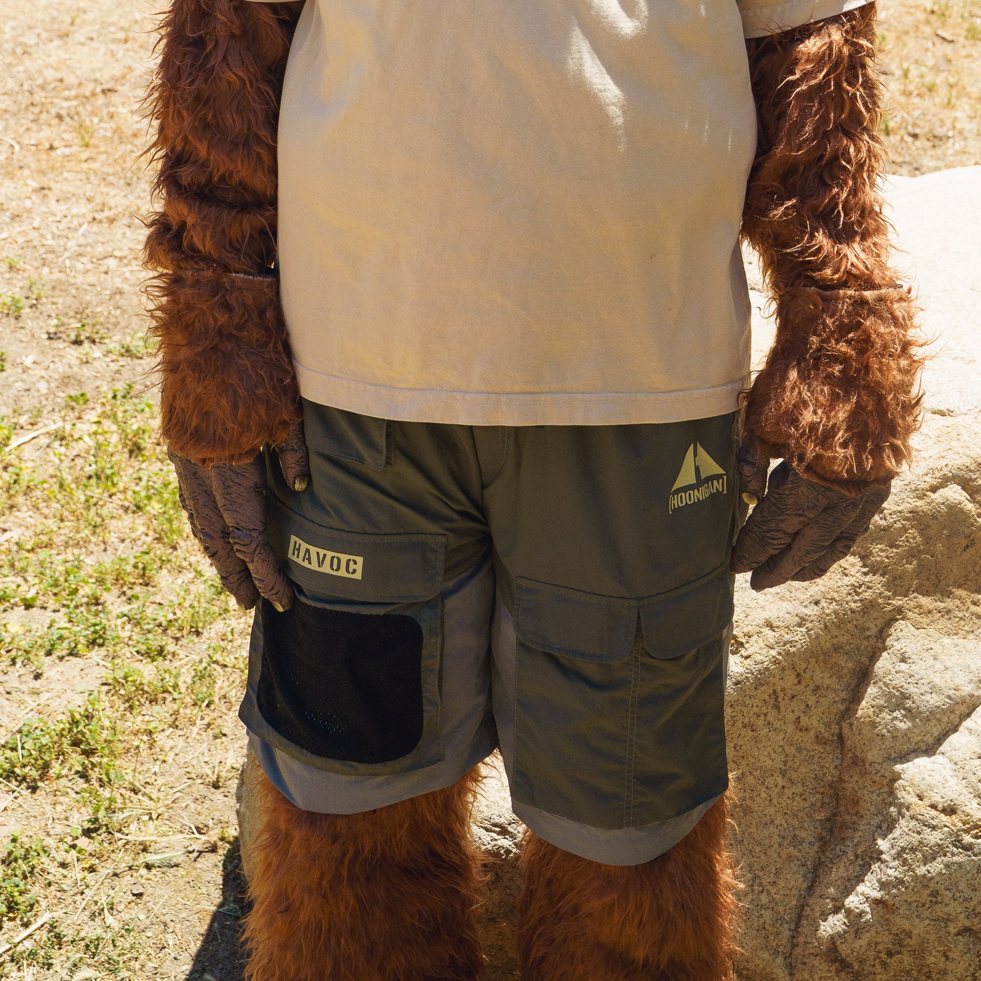 Close-up of Hoonigan H.A.V.O.C. rain-activated cargo shorts on a furry animal, featuring multiple pockets and branding details.