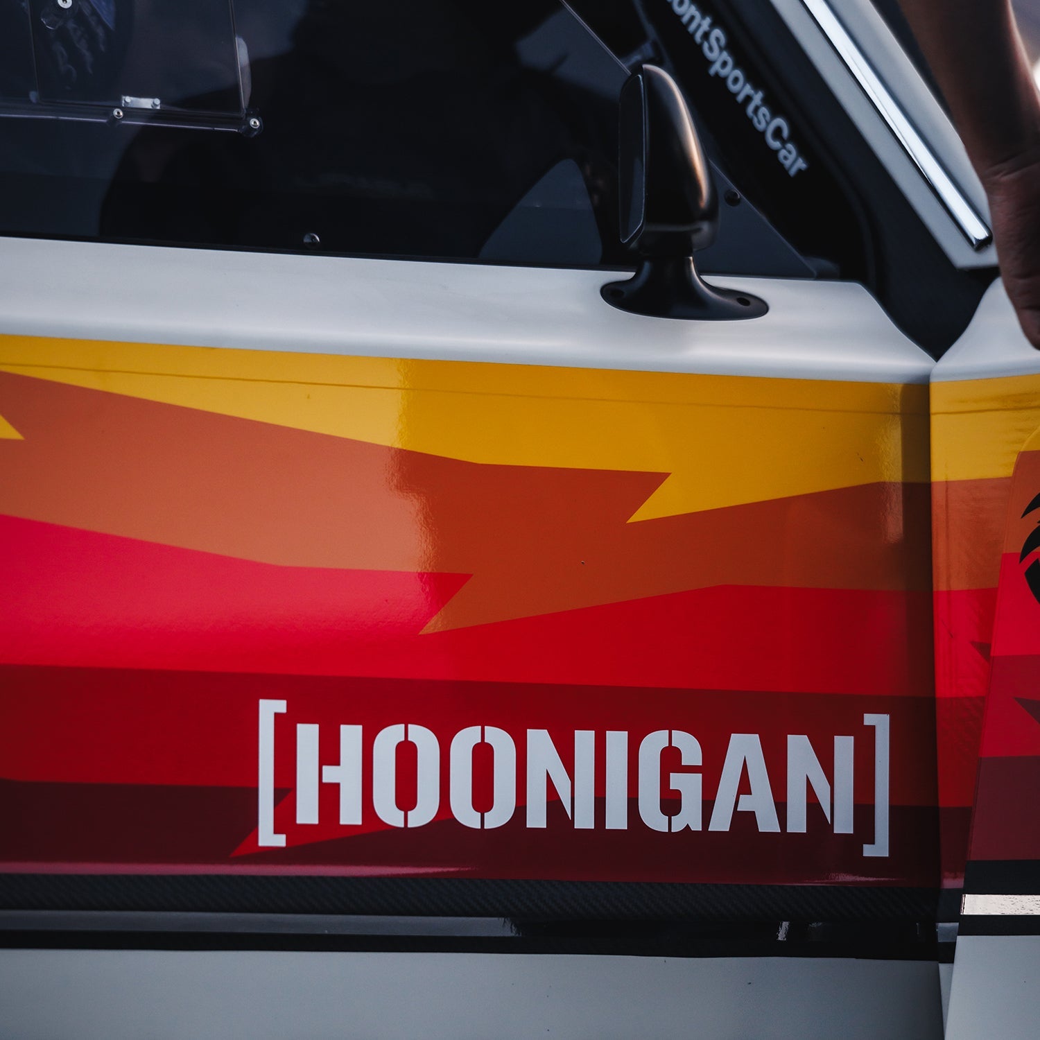 Hoonigan medium die cut censor bar bracket sticker displayed on a car, featuring bold red and yellow graphics.