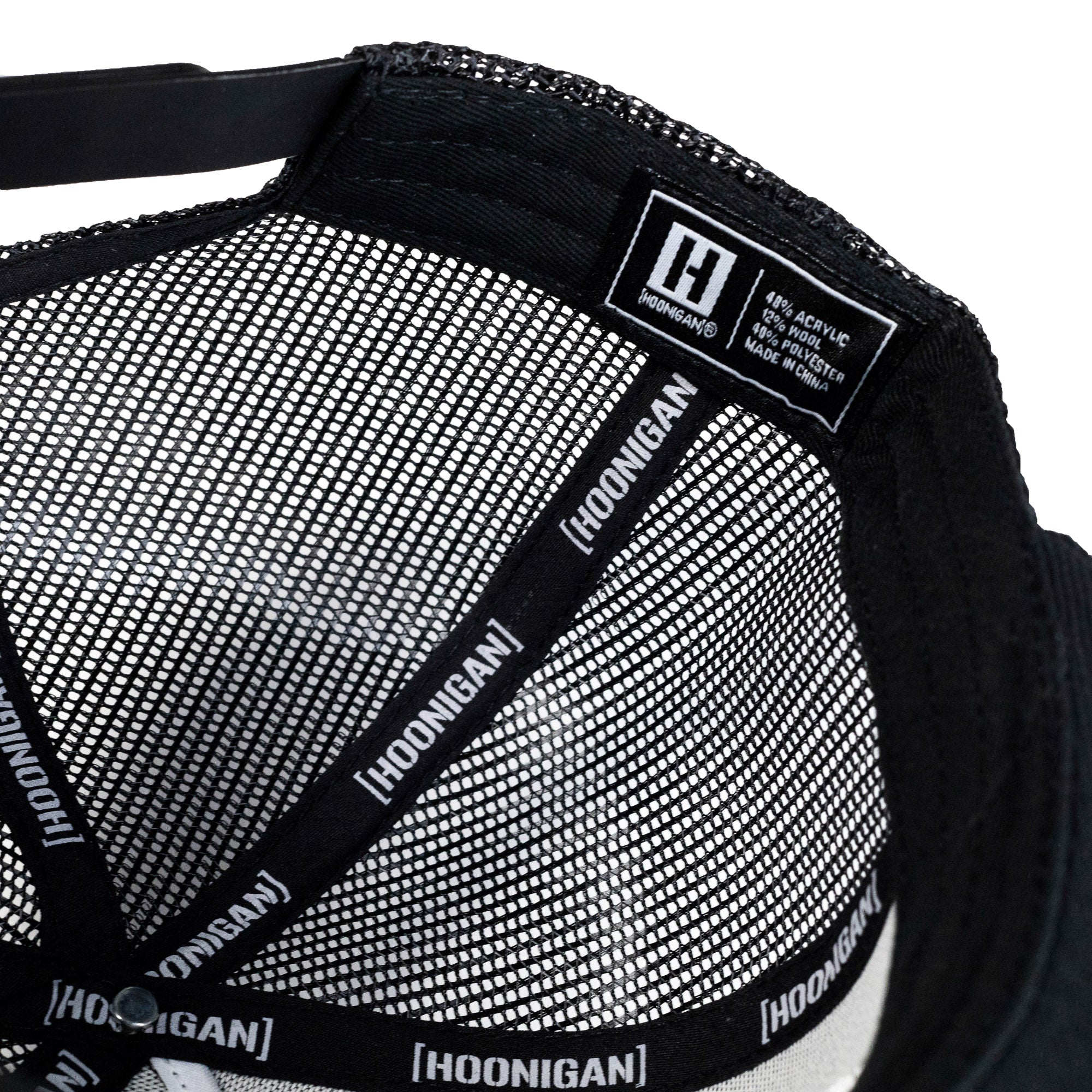 US Mags logo trucker hat with a black front panel and mesh back, featuring a bold embroidered logo in white.