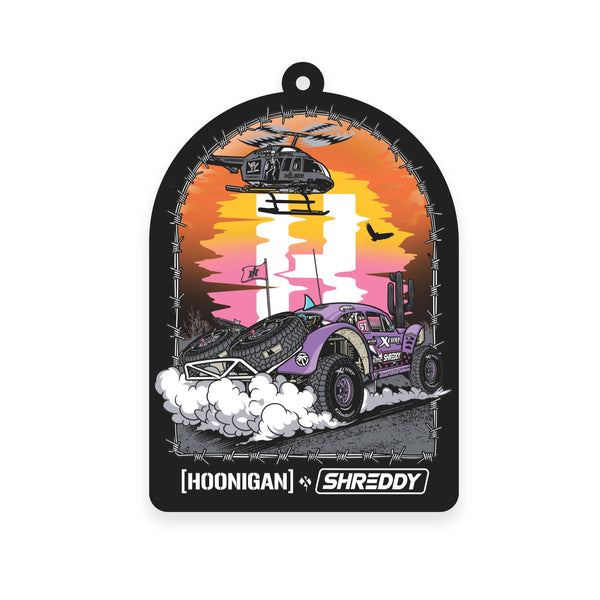 Hoonigan x Shreddy DESERT Air Freshener featuring a vibrant off-road vehicle and helicopter against a sunset backdrop.