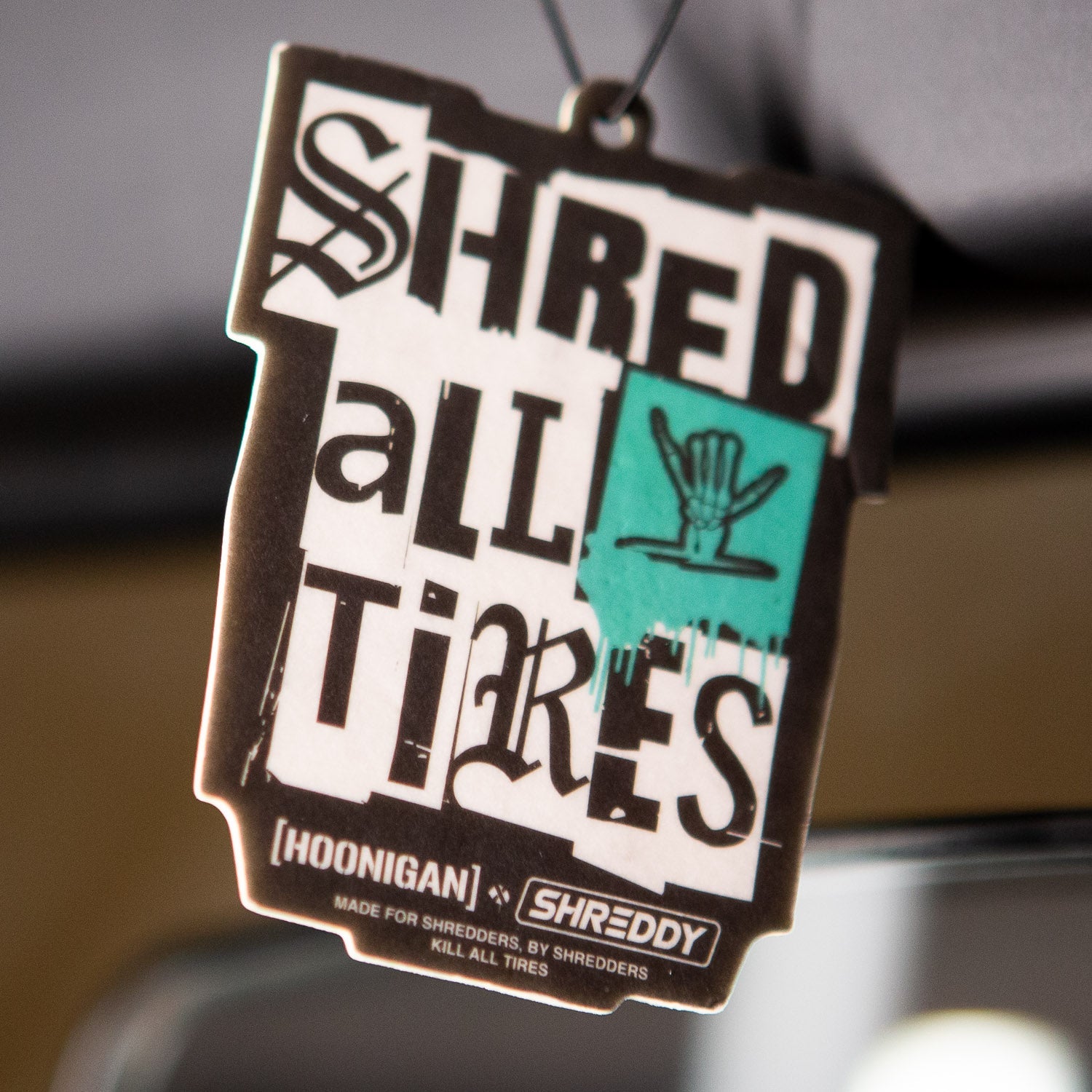 Hoonigan x Shreddy SHRED ALL TIRES air freshener featuring bold graphics and a playful design for car enthusiasts.