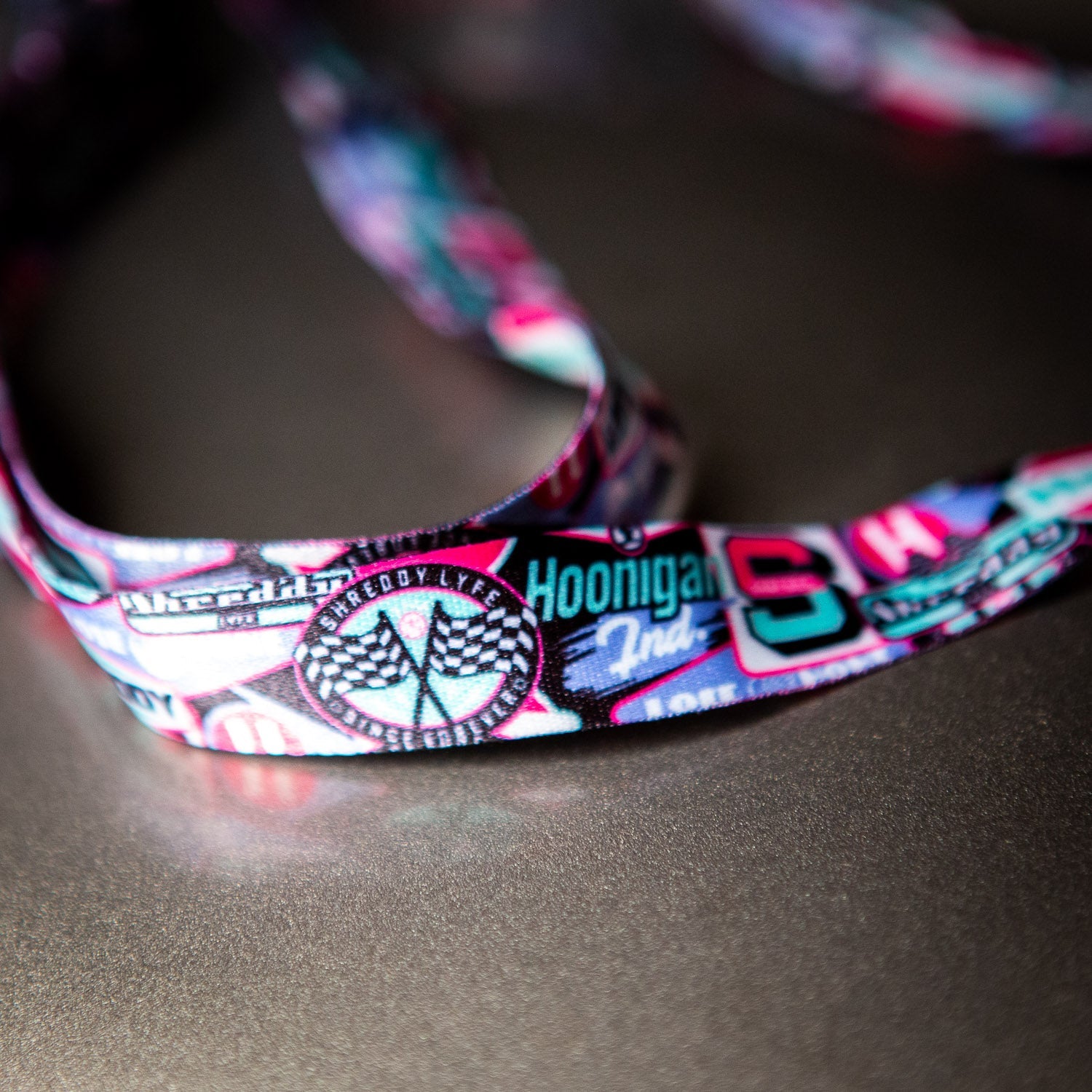 Colorful Hoonigan x Shreddy lanyard featuring logos and graphics, perfect for motorsport enthusiasts and daily use.