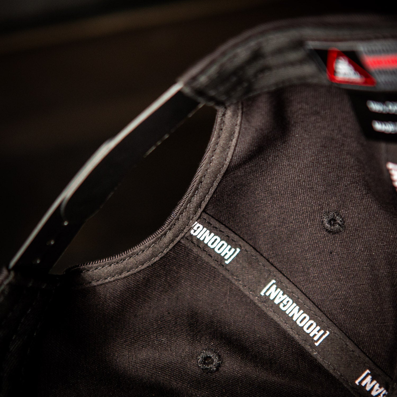 Interior view of the Hoonigan PATRIOT Snapback Hat showcasing the brand label and stitching details.