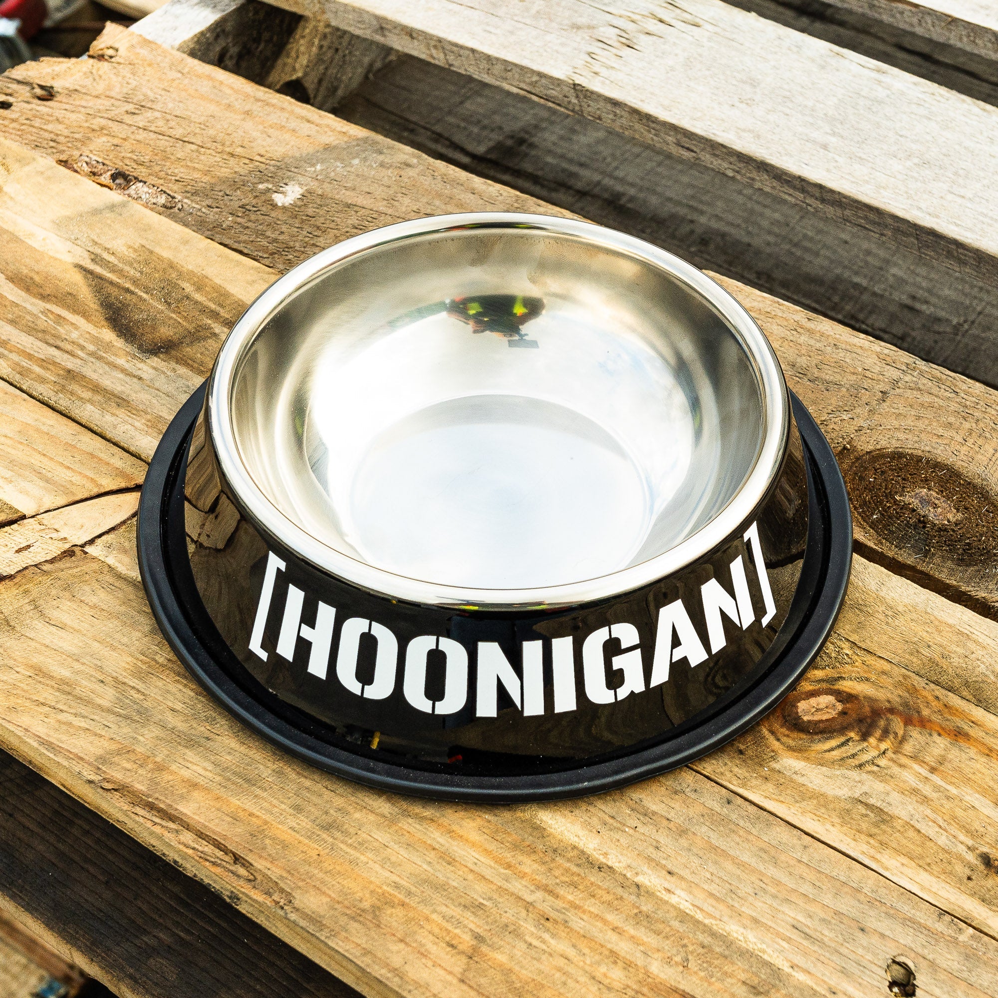 Stainless steel dog bowl with Hoonigan logo on a black base, designed for automotive enthusiasts and pet lovers.