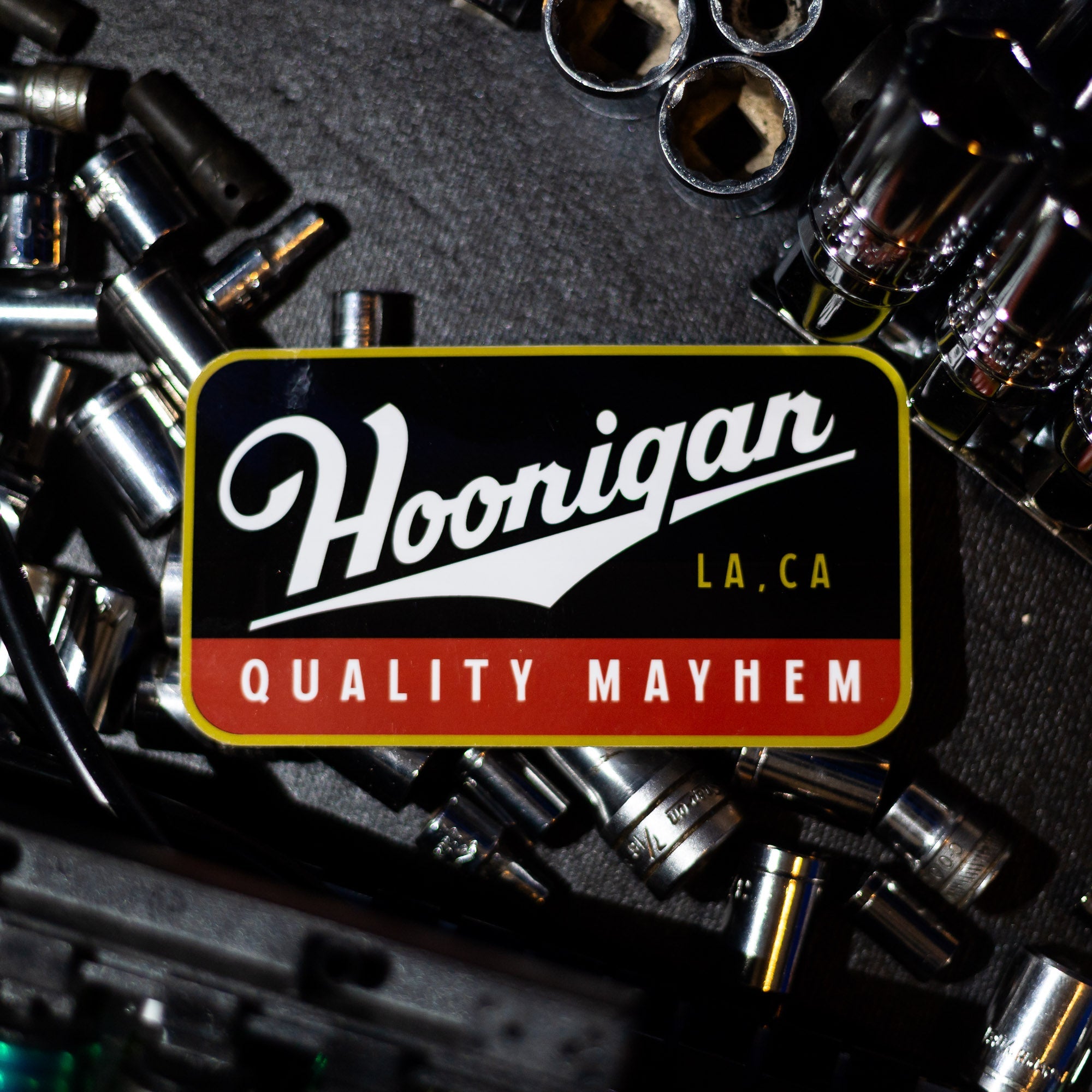 Hoonigan Champagne sticker featuring bold text and a vintage design, perfect for automotive enthusiasts.