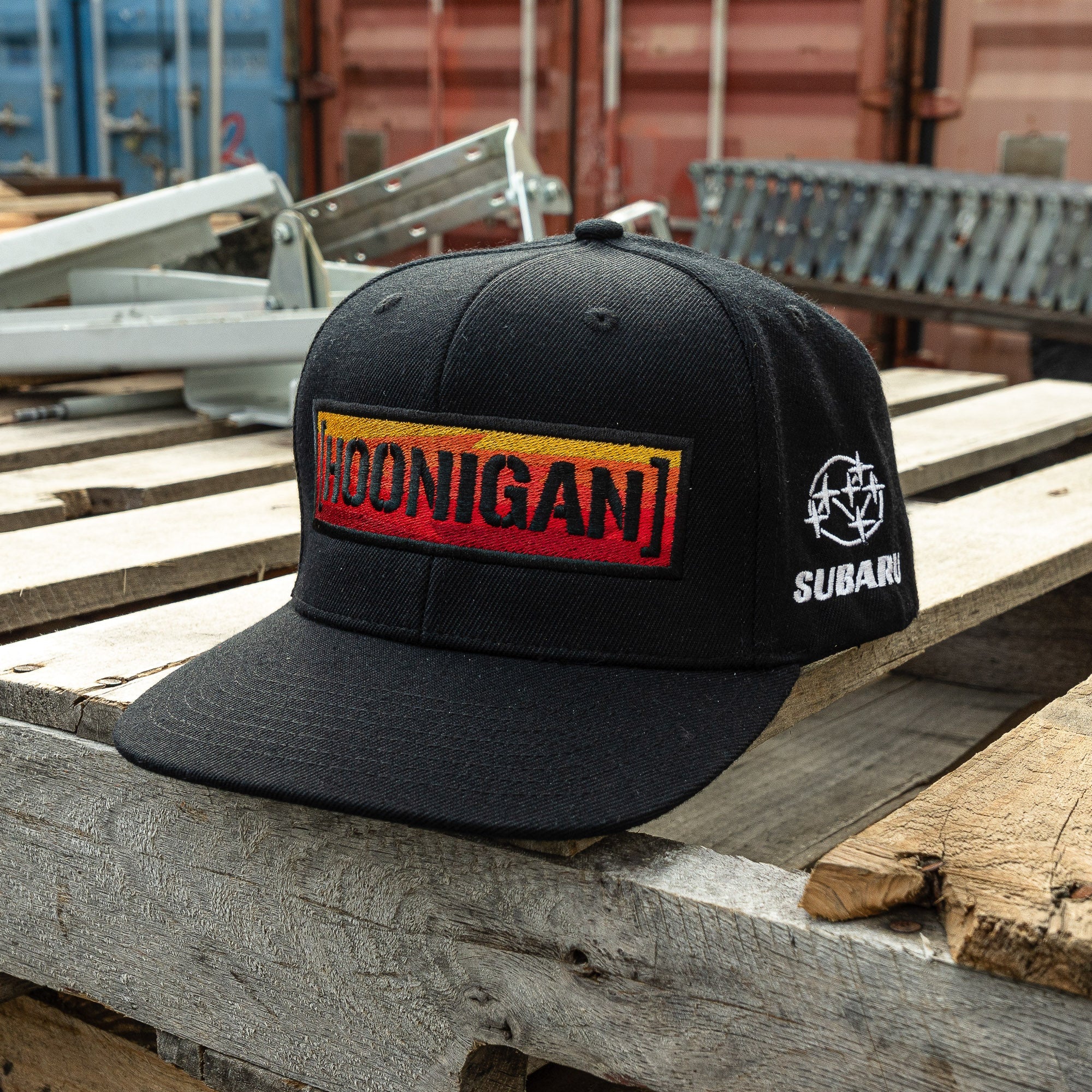 Black snapback hat featuring a bold Hoonigan logo and Subaru emblem, perfect for motorsport enthusiasts and car culture fans.